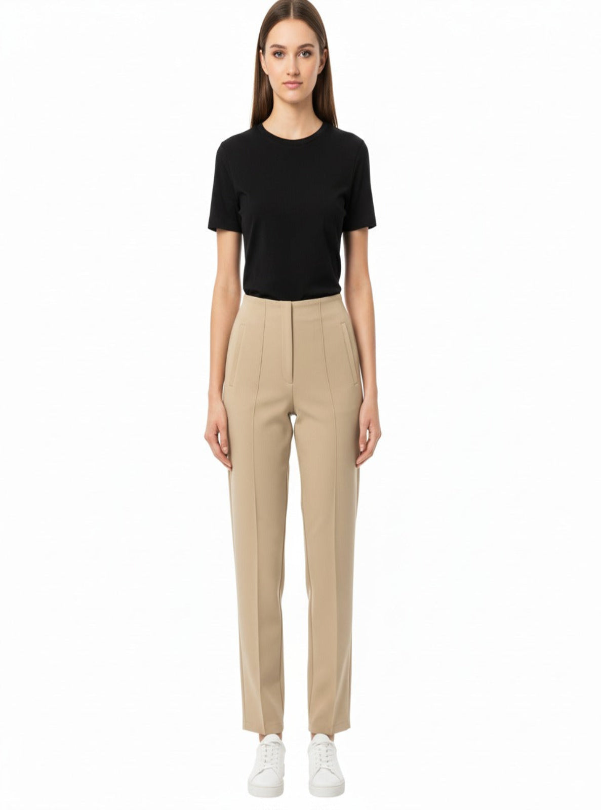 Woman wearing a black t-shirt and beige pants on a white background
