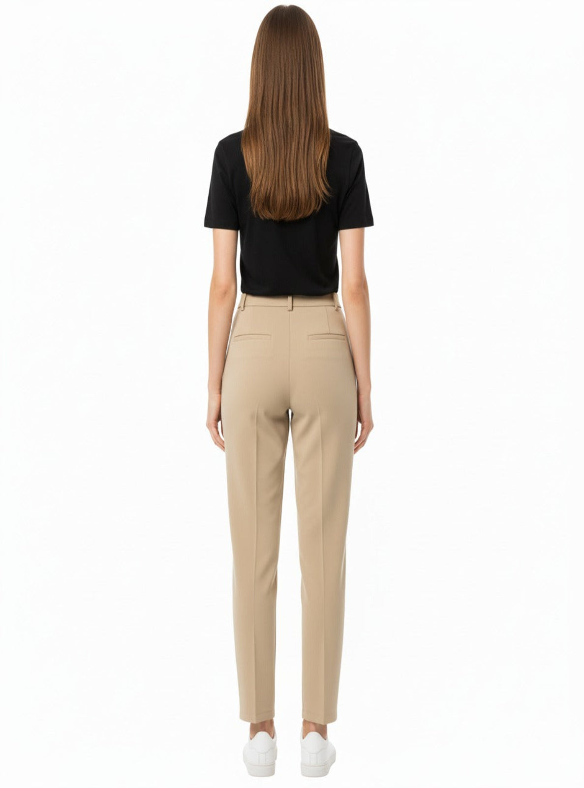 Woman wearing beige pants and a black top on a white background