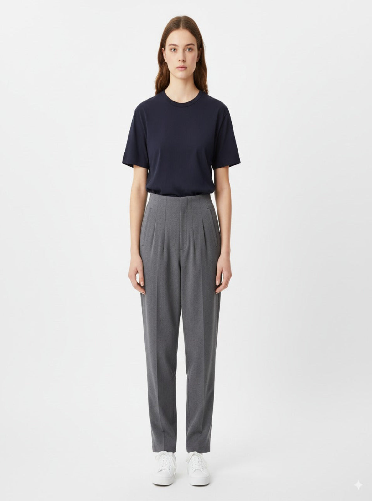 Person wearing a navy t-shirt and gray pants on a white background