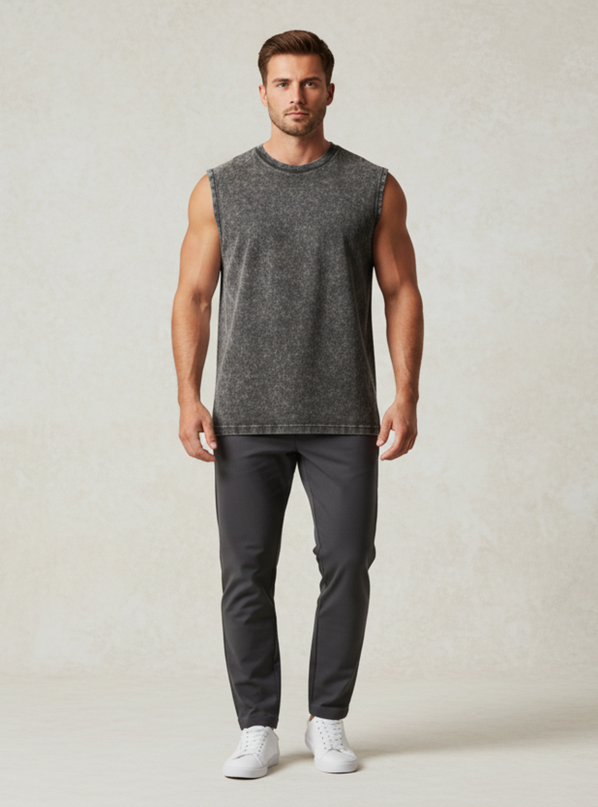 Man wearing a gray sleeveless shirt and pants on a plain background