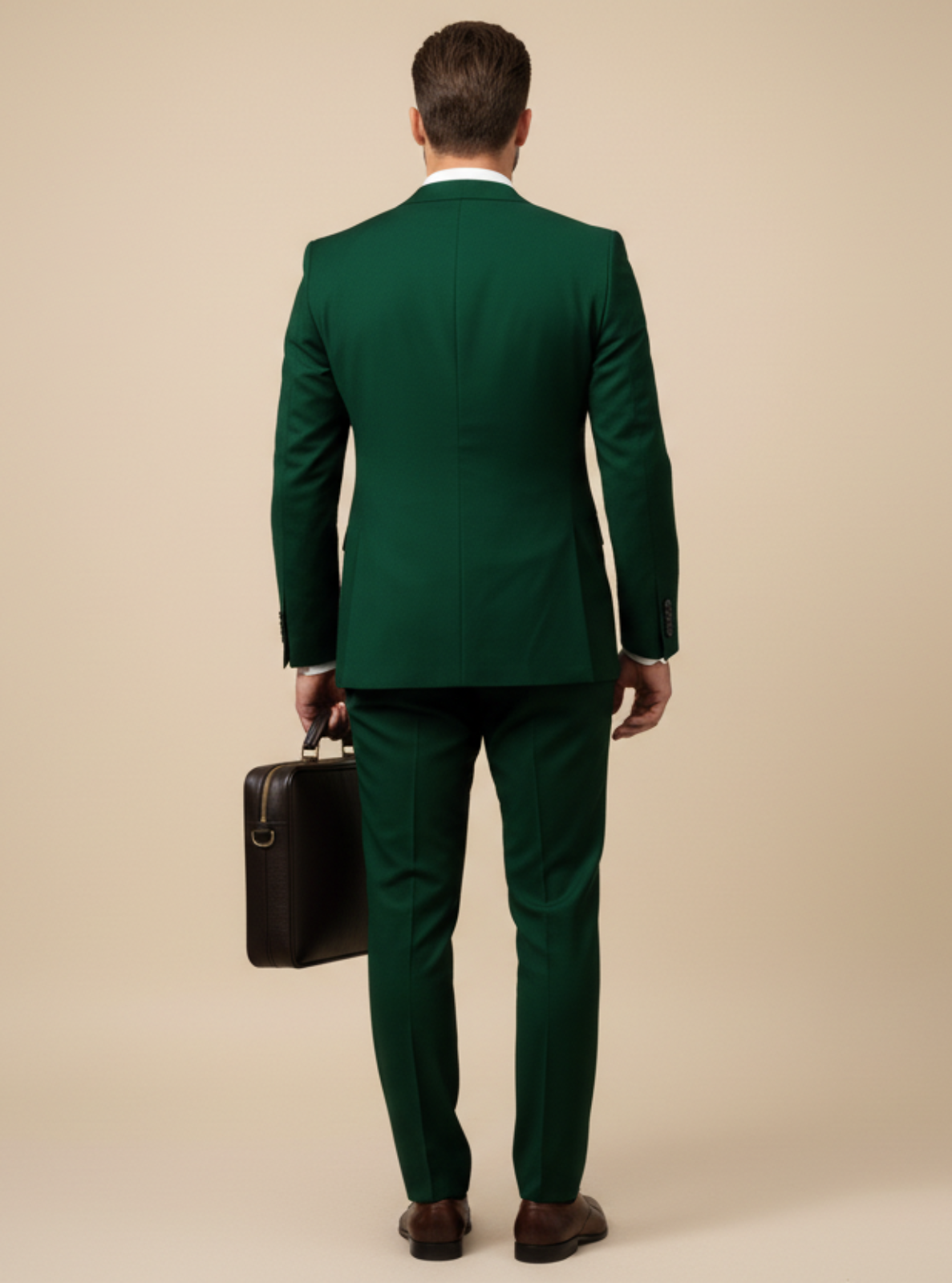 Man in a green suit holding a briefcase on a beige background