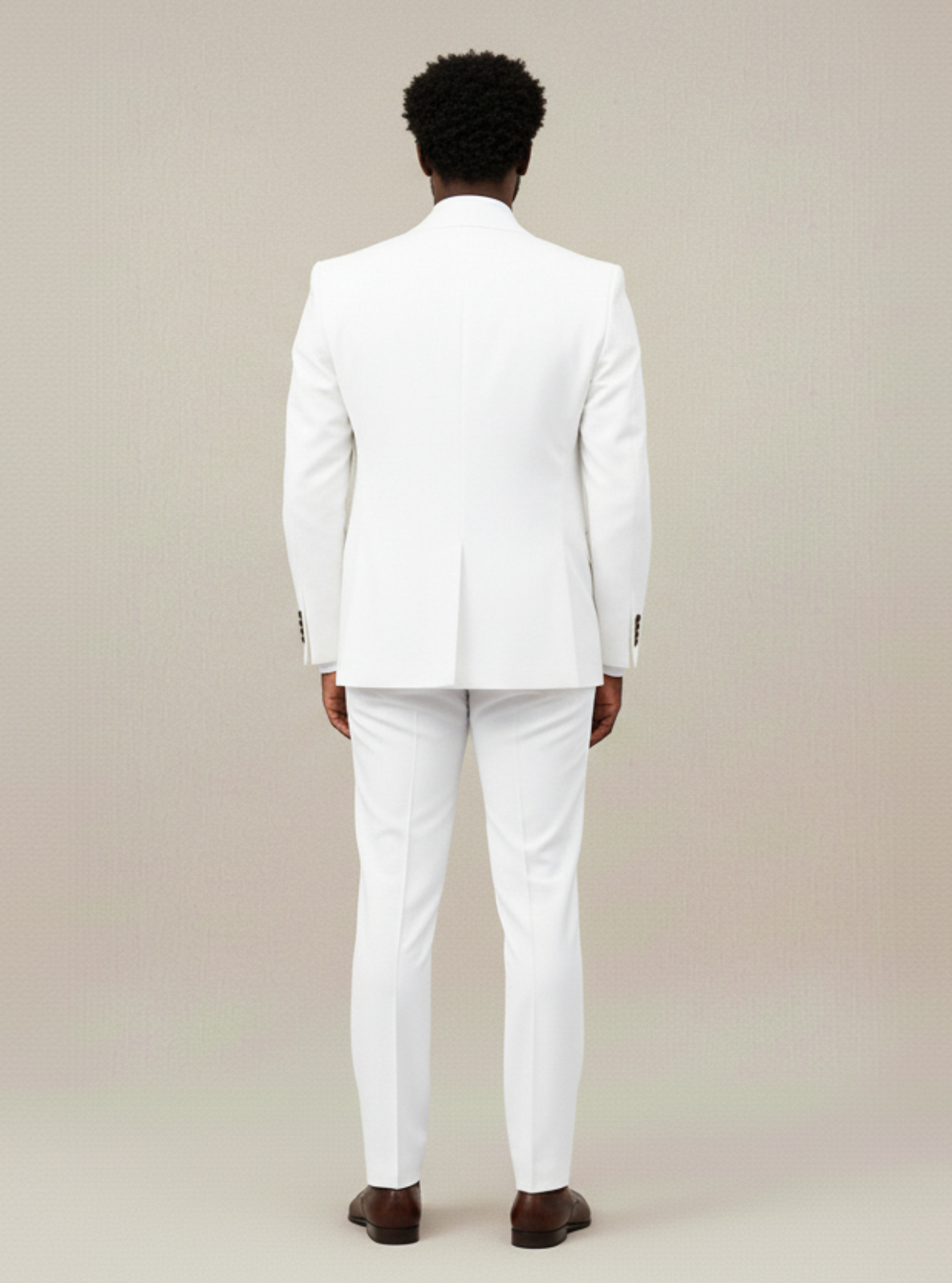 Man wearing a white suit standing against a plain background