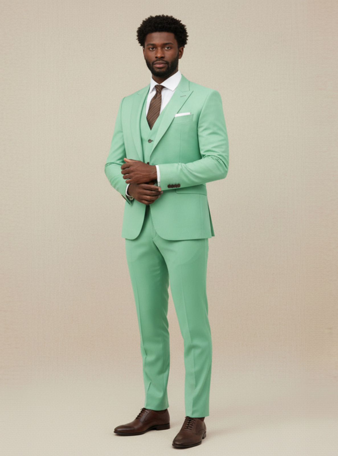 Man wearing a mint green suit with a white shirt and brown shoes on a beige background