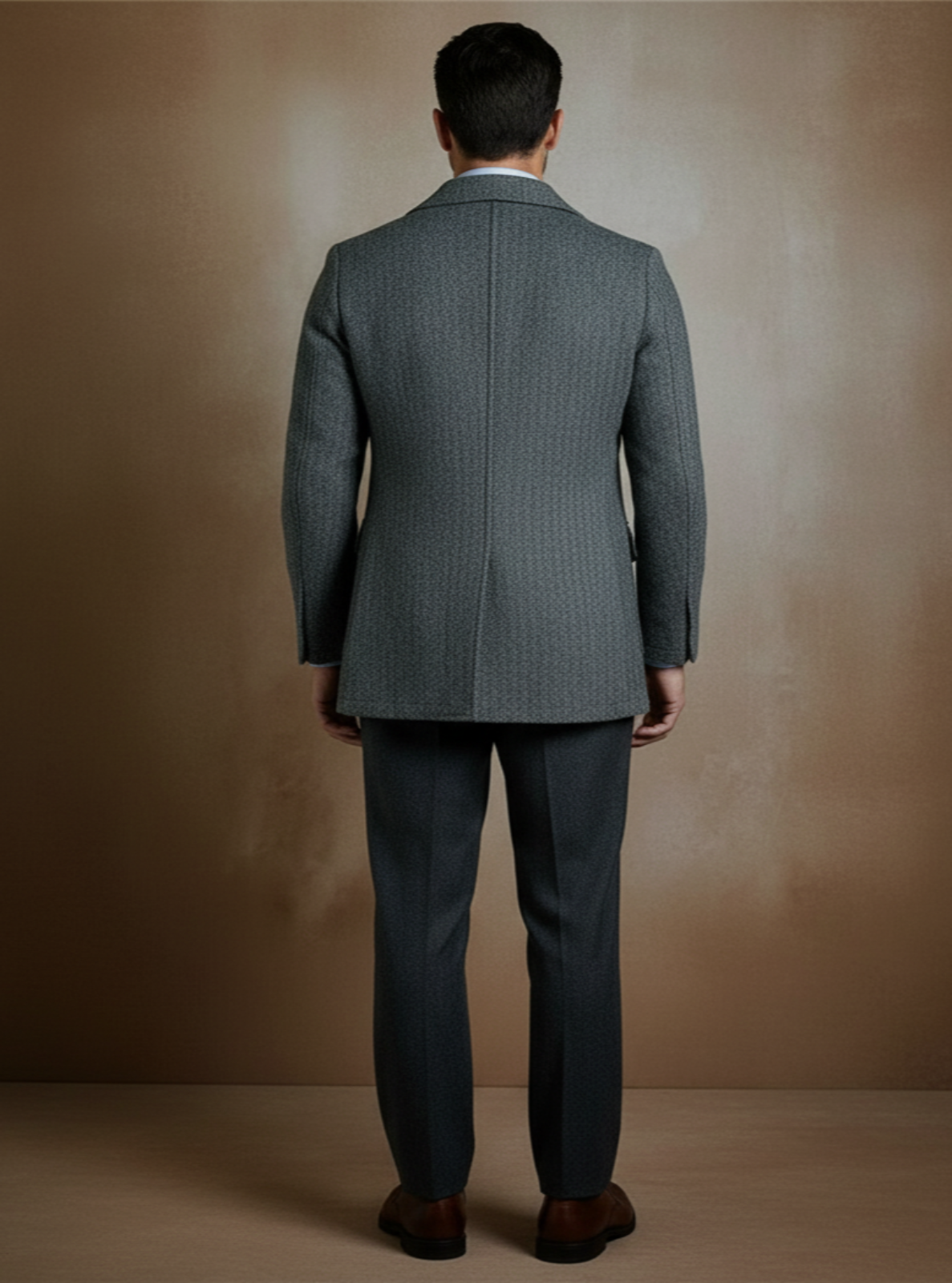 Man wearing a gray suit against a beige background