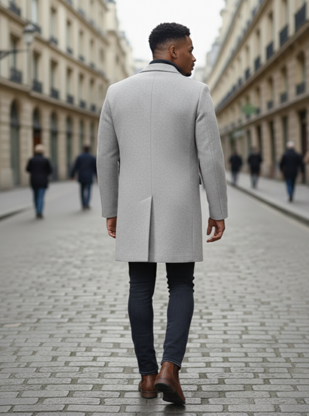 Man wearing a gray coat walking down a city street