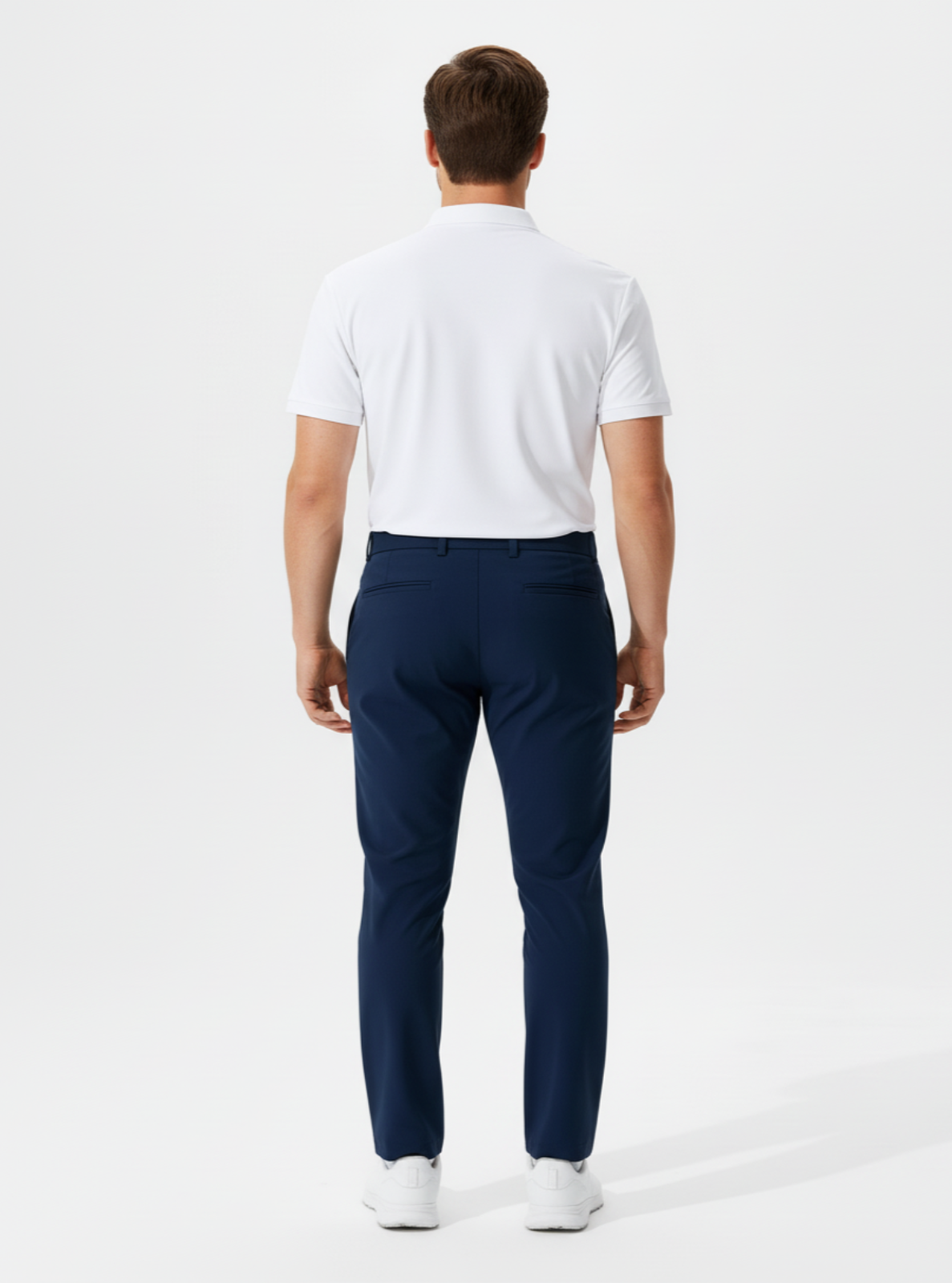 Man wearing a white polo shirt and navy pants on a white background