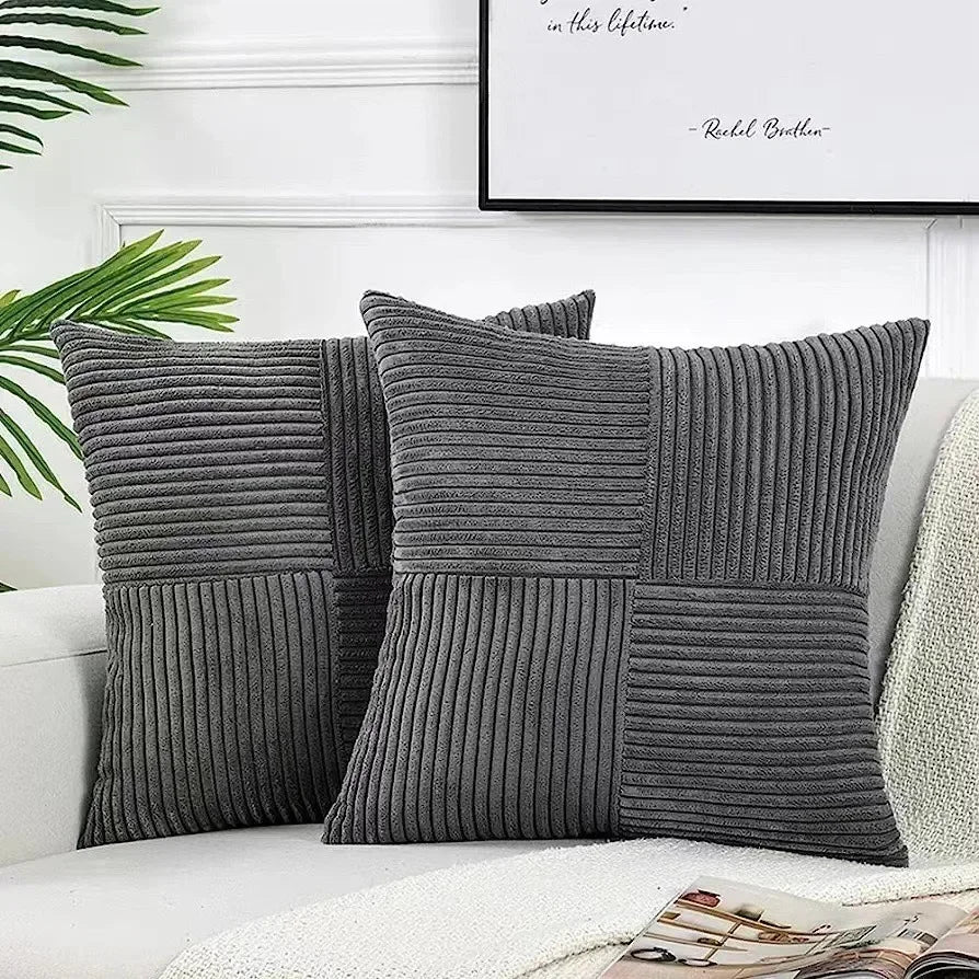 Gray textured throw pillows on a sofa with a plant and framed quote in the background.