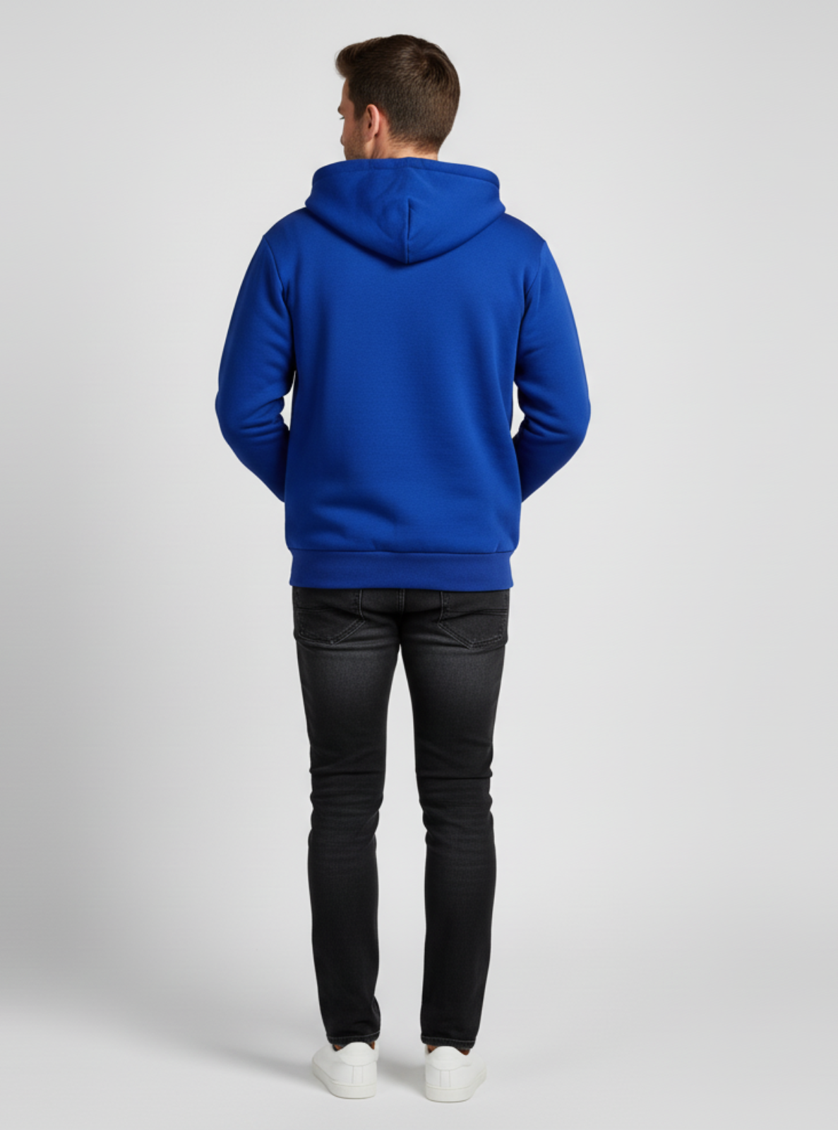 Person wearing a blue hoodie and black pants on a white background