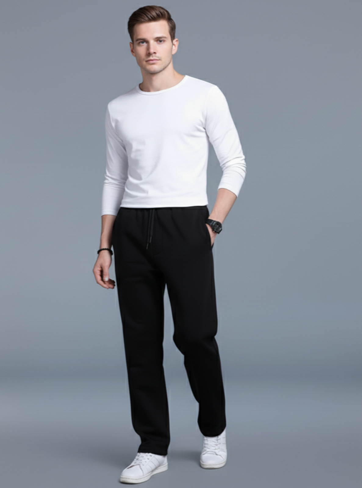 Man wearing a white sweater and black pants on a gray background
