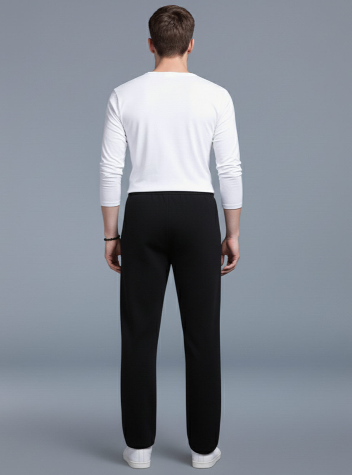 Man wearing a white long-sleeve shirt and black pants on a gray background