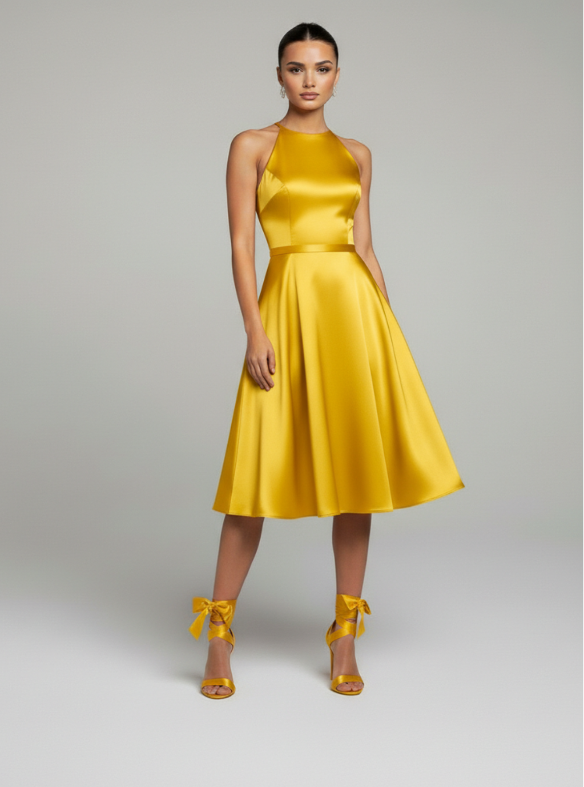 Woman wearing a yellow dress with matching shoes on a gray background