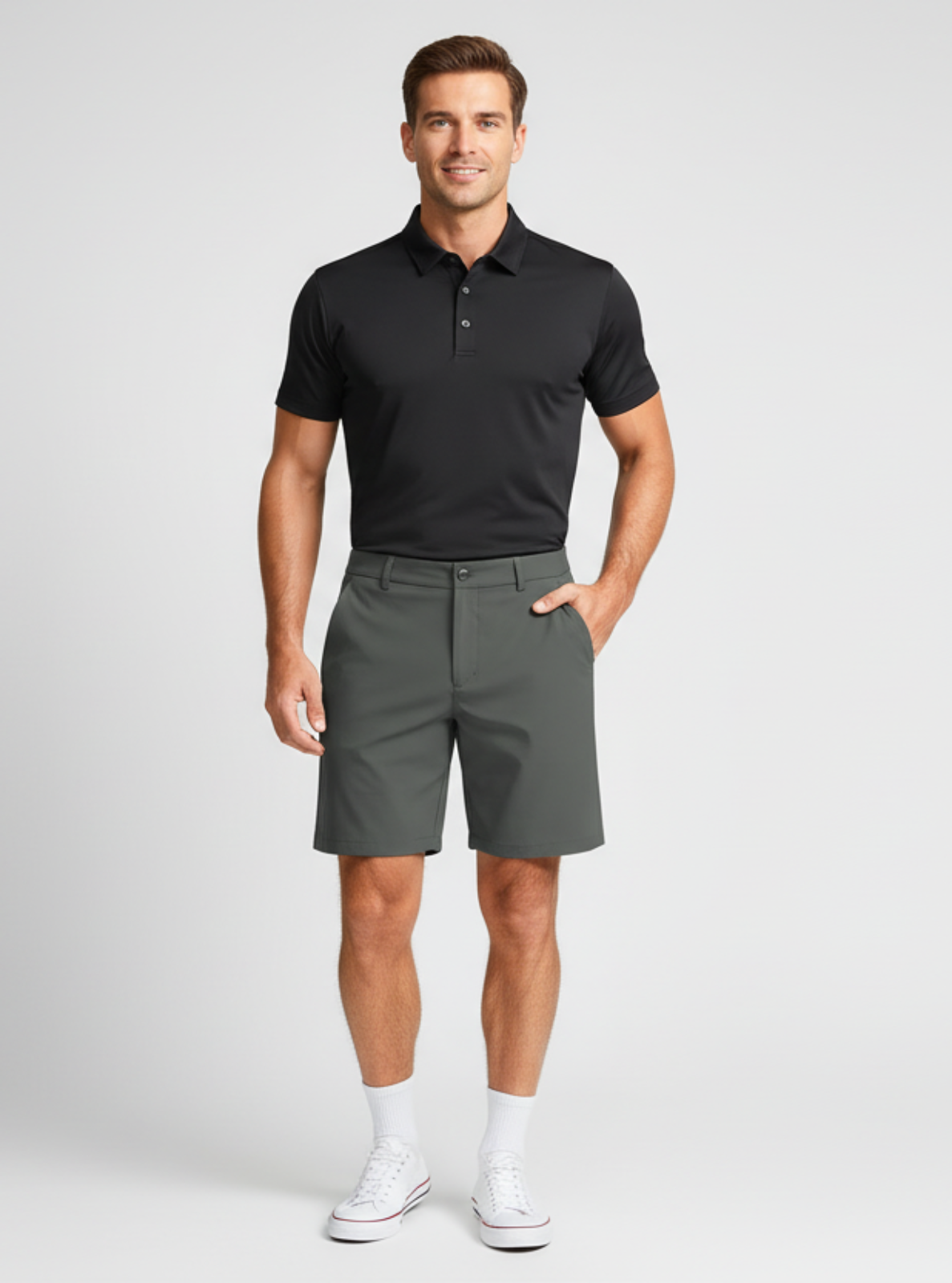Man wearing a black polo shirt and gray shorts on a white background