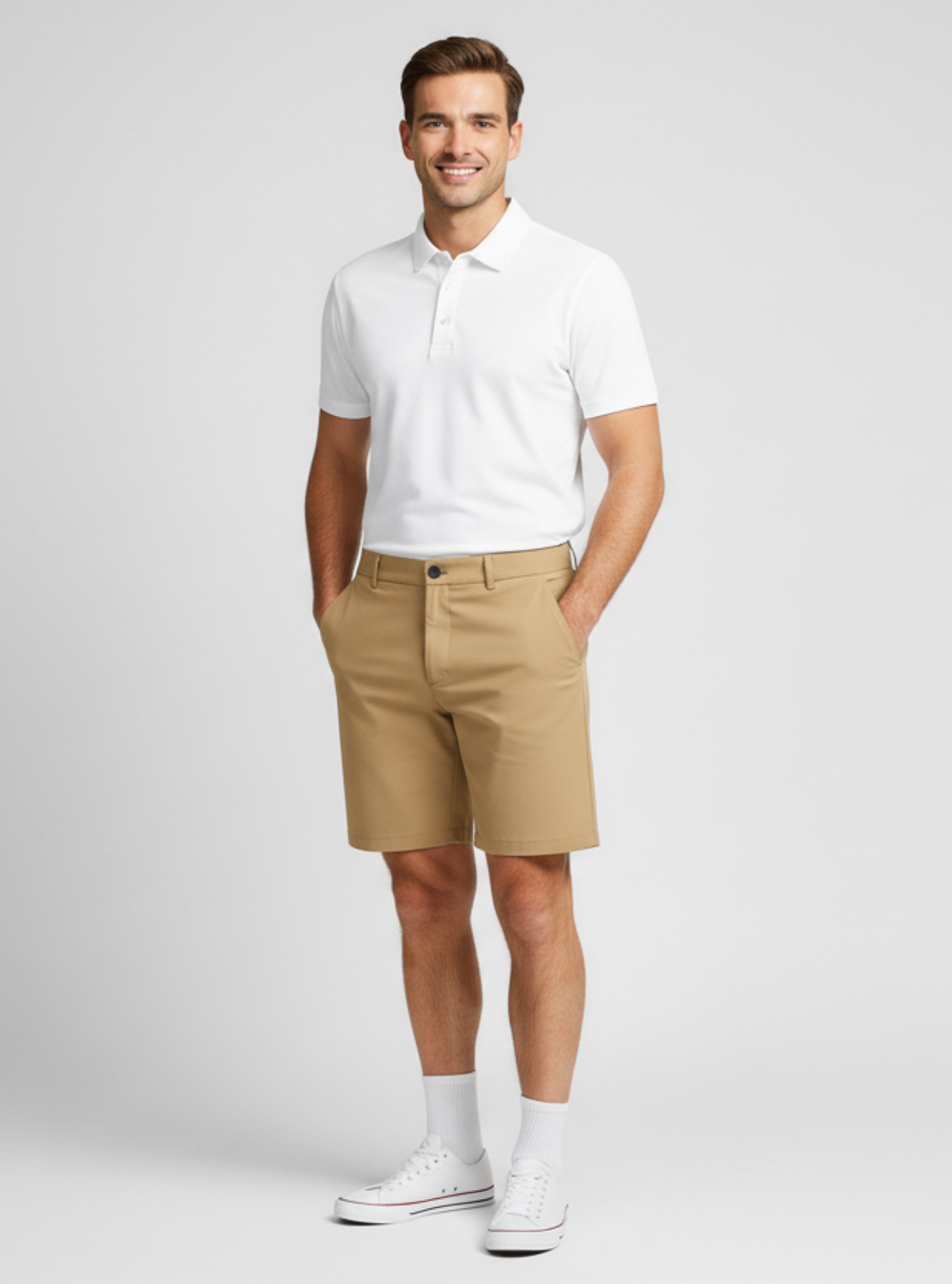 Man wearing a white polo shirt and beige shorts on a light gray background
