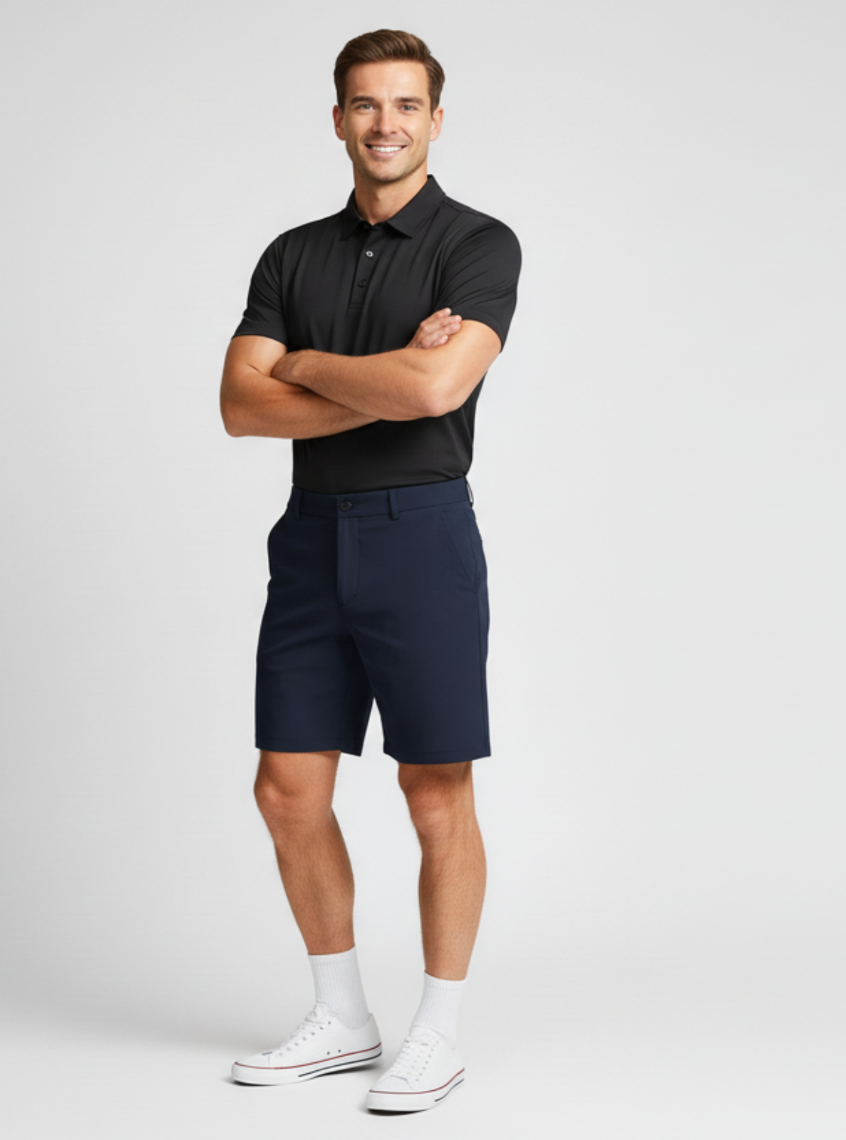 Man wearing a black polo shirt and navy shorts on a white background