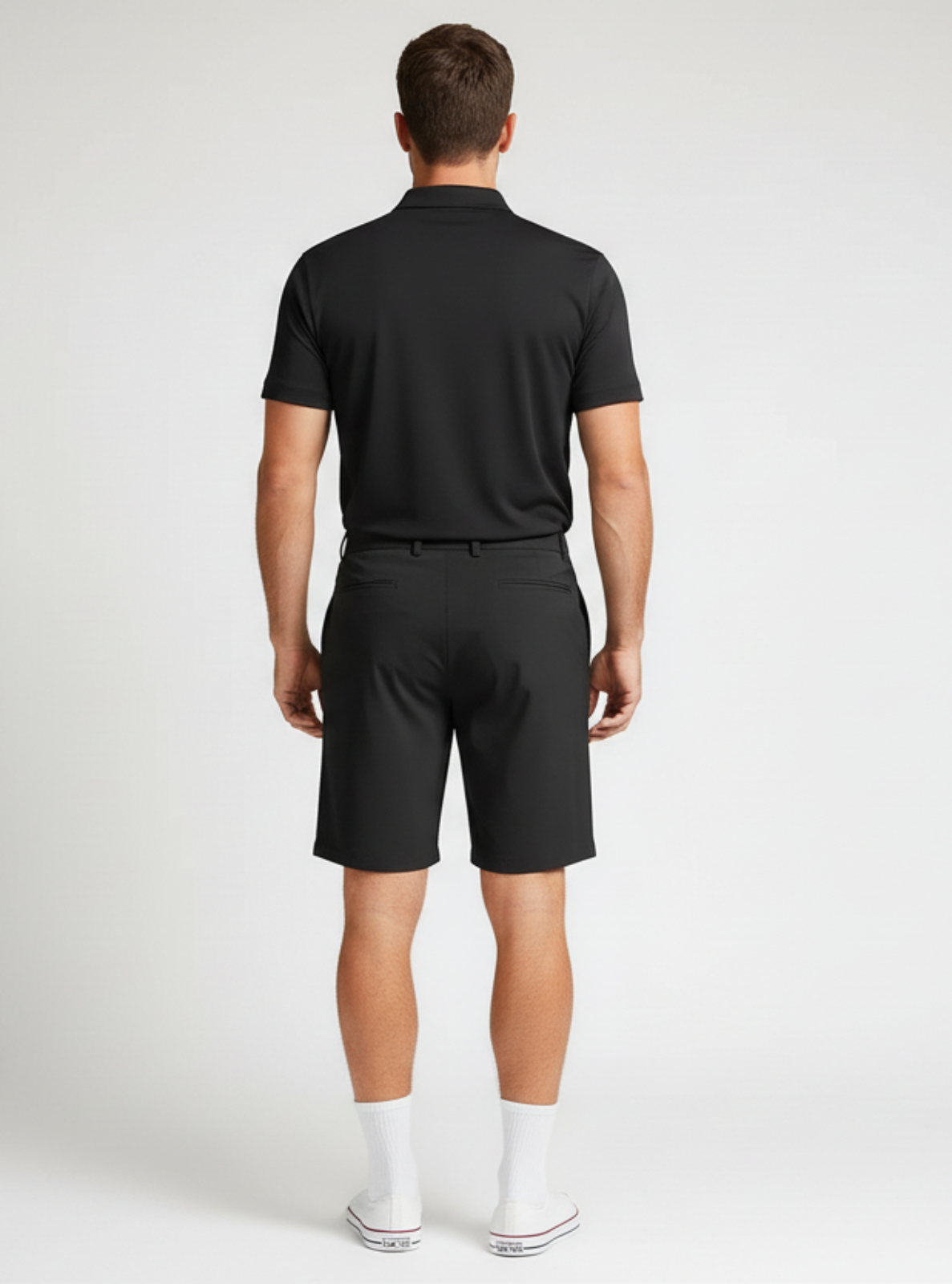 Man wearing a black polo shirt and shorts on a white background