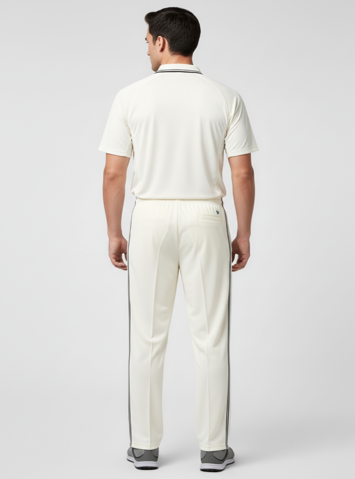 Man wearing a white polo shirt and pants on a light gray background
