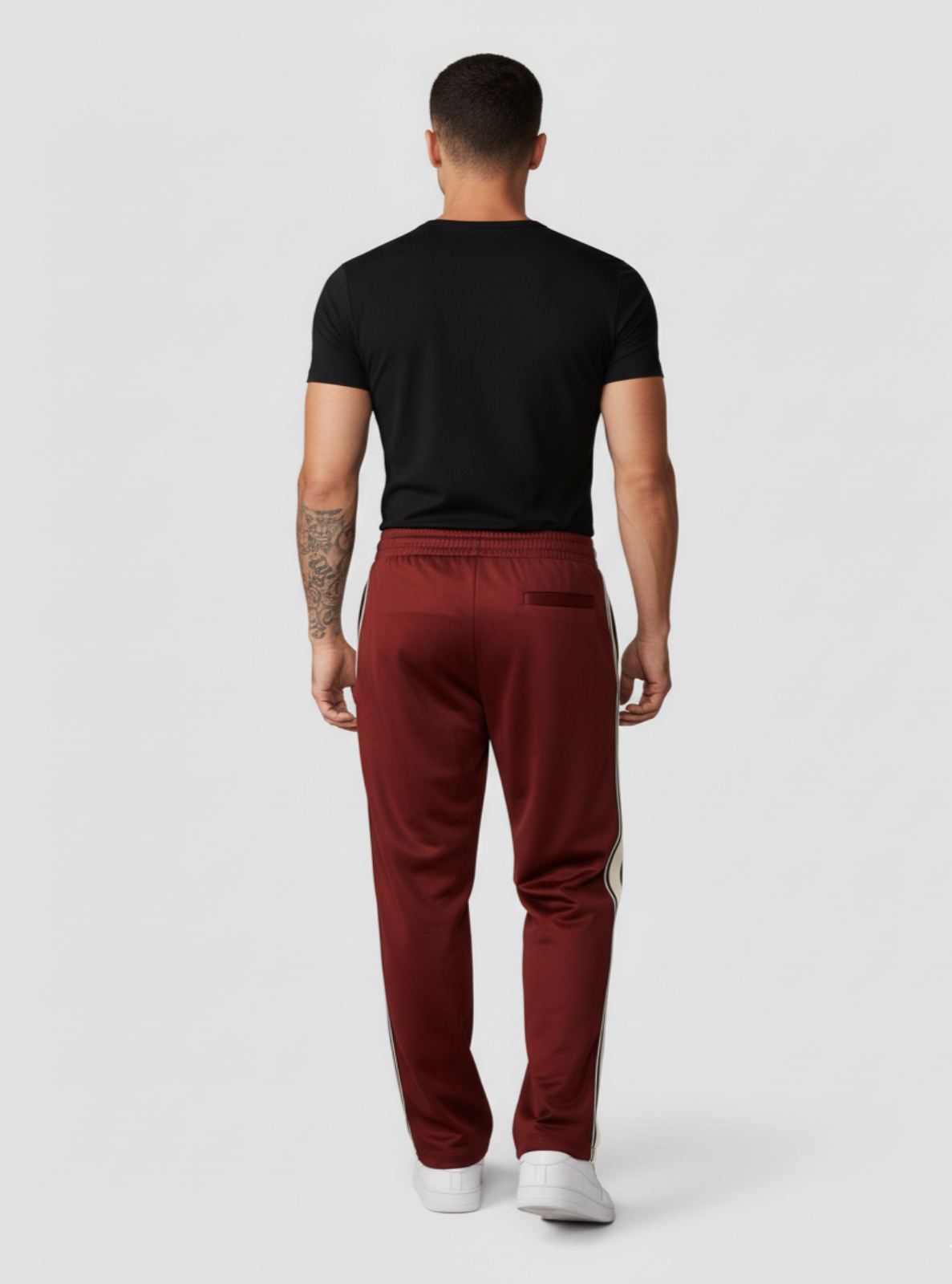Person wearing a black t-shirt and red pants on a white background