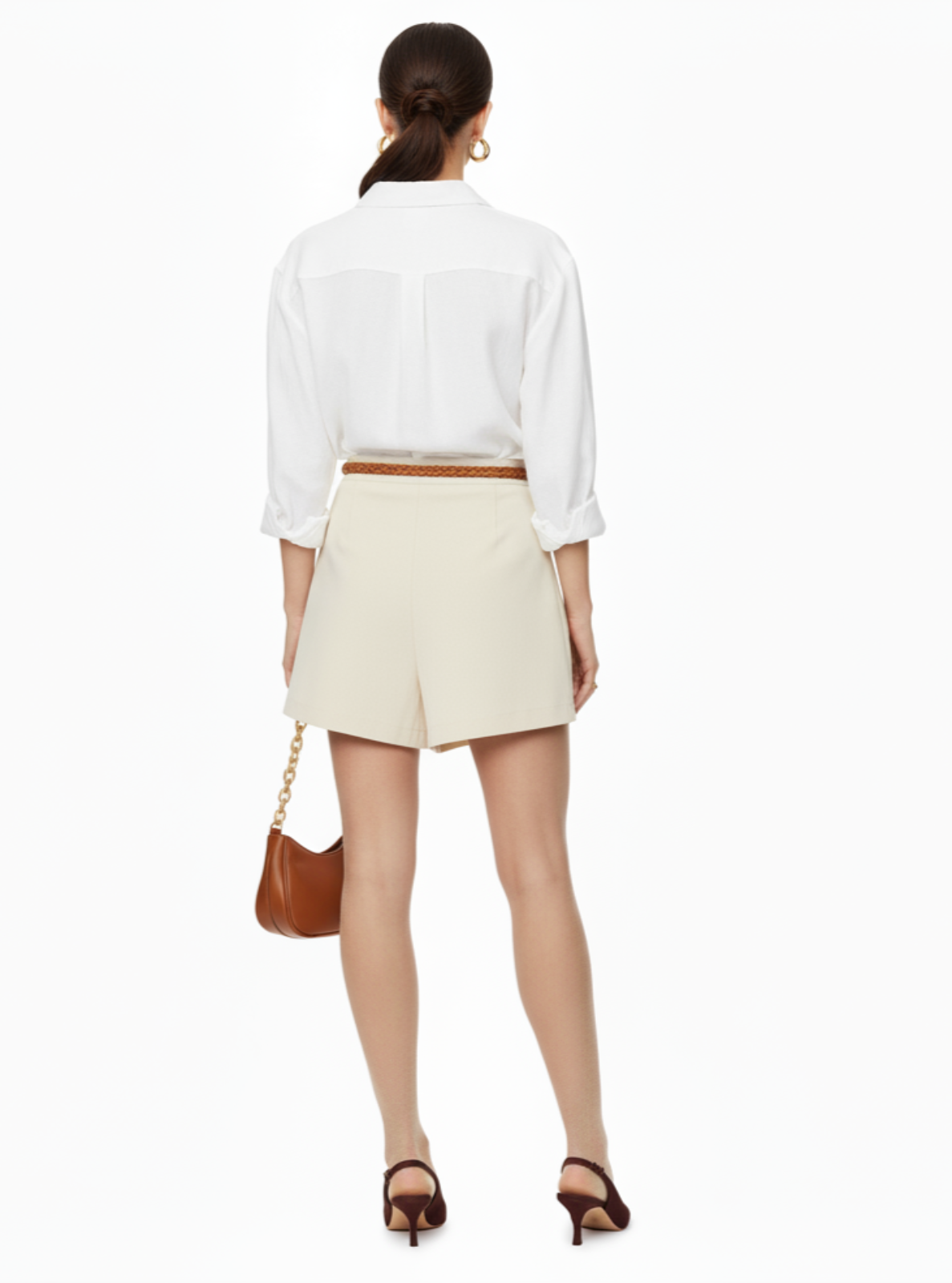 Woman wearing a white blouse and beige shorts on a white background