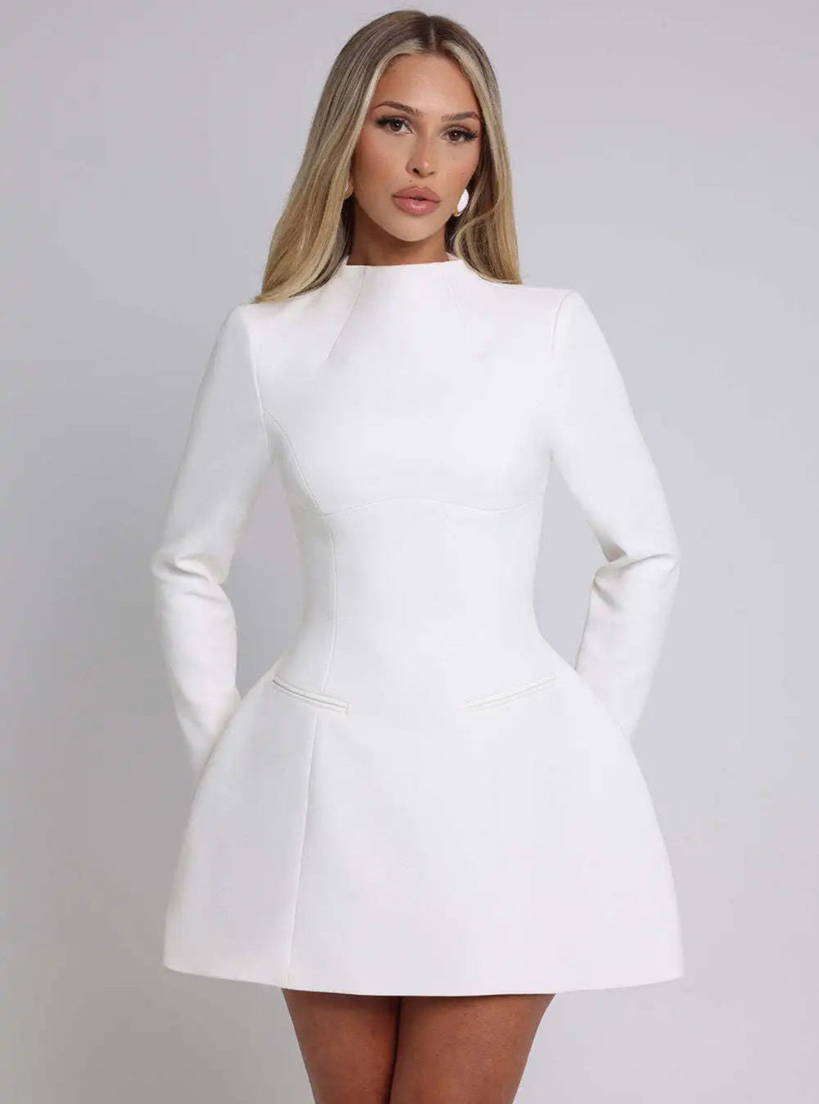 Woman wearing a white dress against a gray background