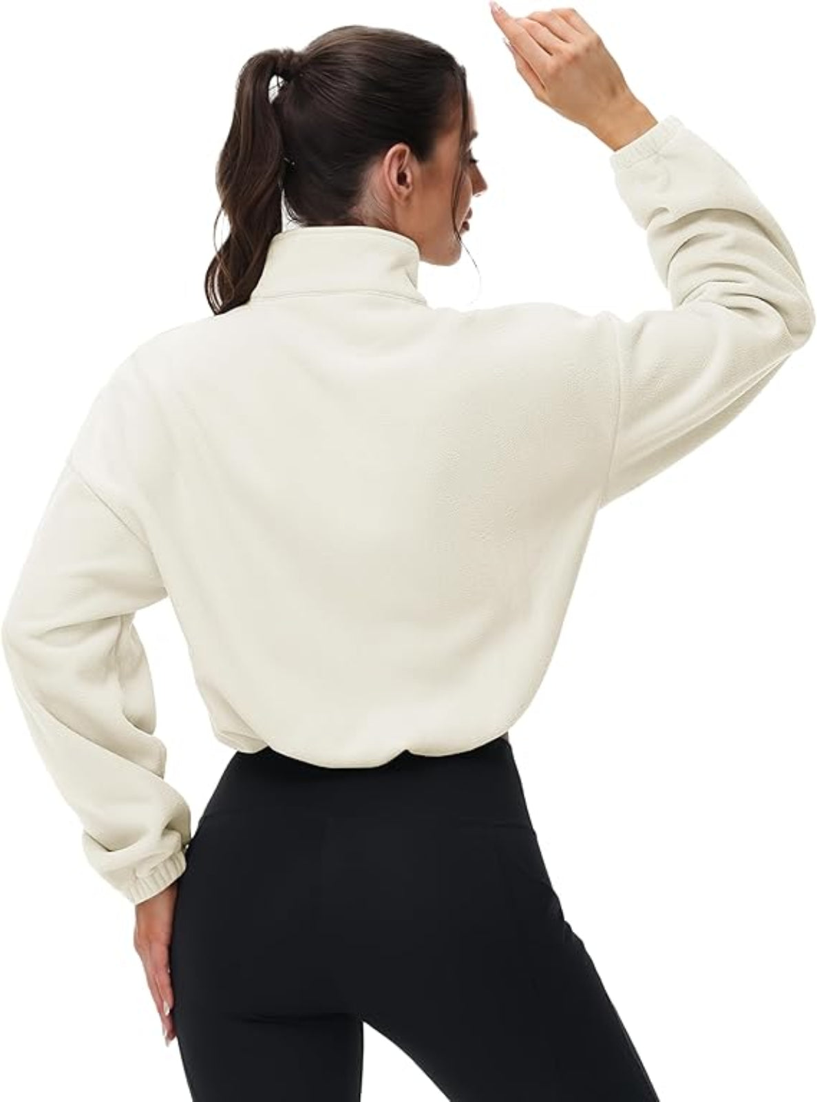 Woman wearing a beige long-sleeve top with a high collar on a white background