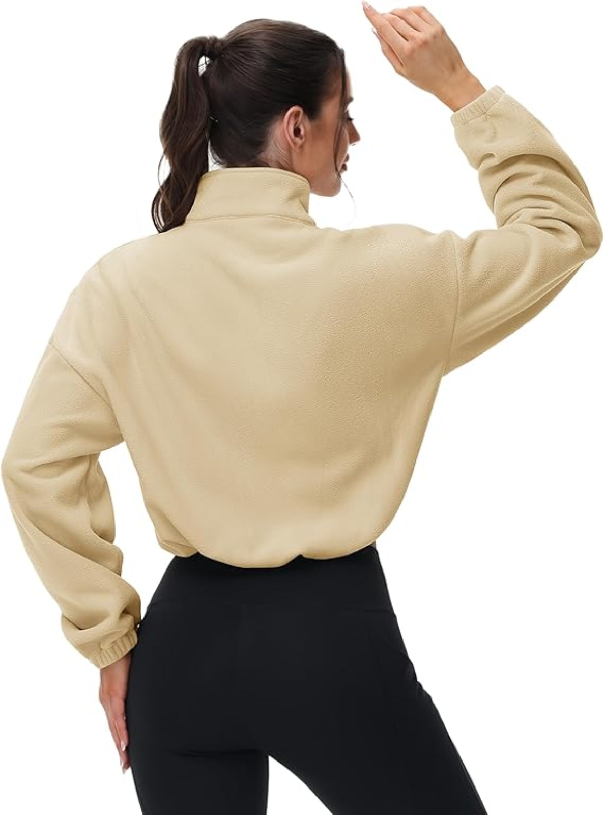 Person wearing a beige jacket and black pants on a white background