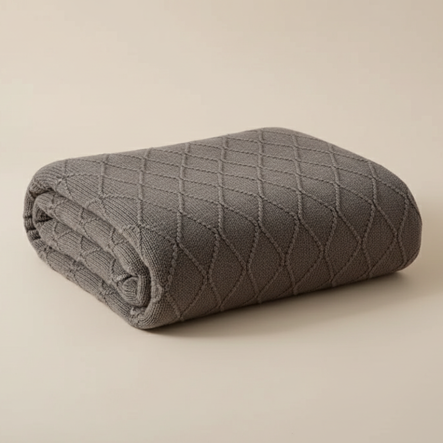 Folded gray quilt on a beige background