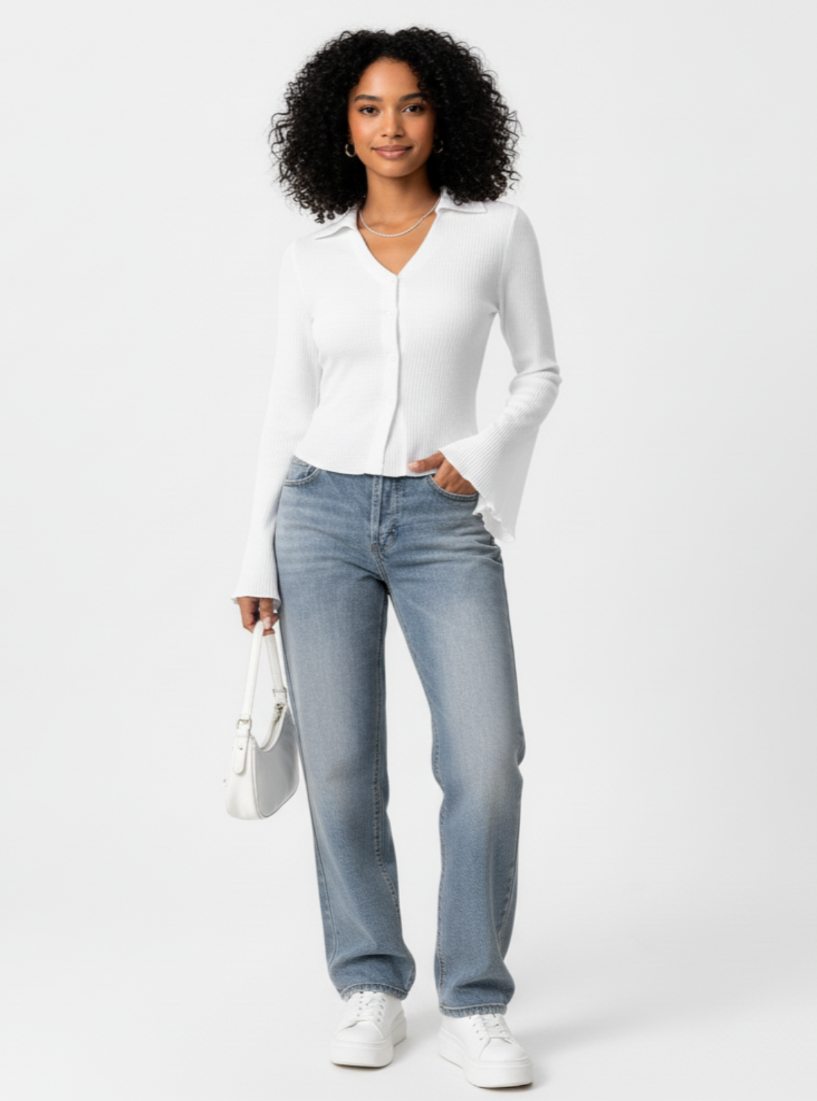 Woman wearing a white shirt, light blue jeans, and white sneakers on a white background