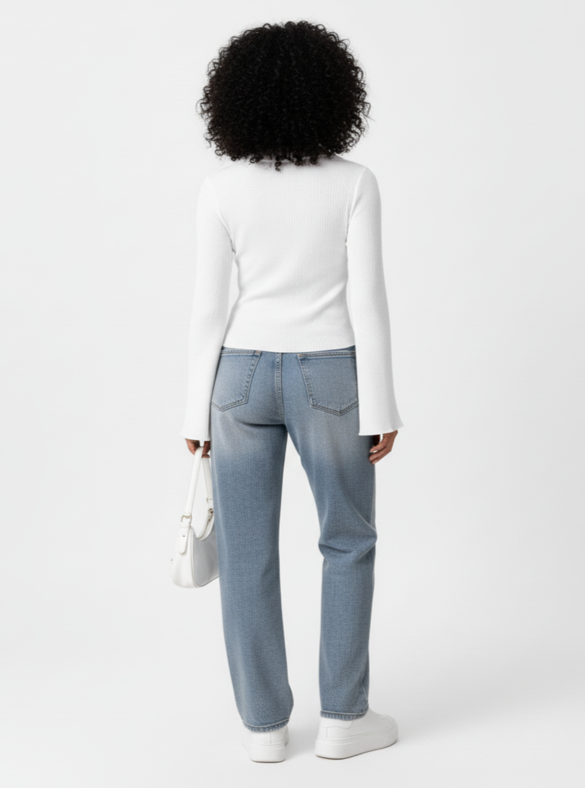 Person wearing a white long-sleeve shirt and light blue jeans on a white background