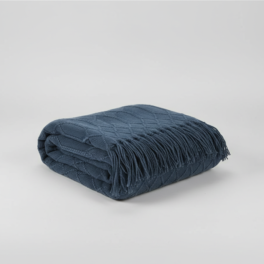 Folded blue blanket with fringes on a light gray background