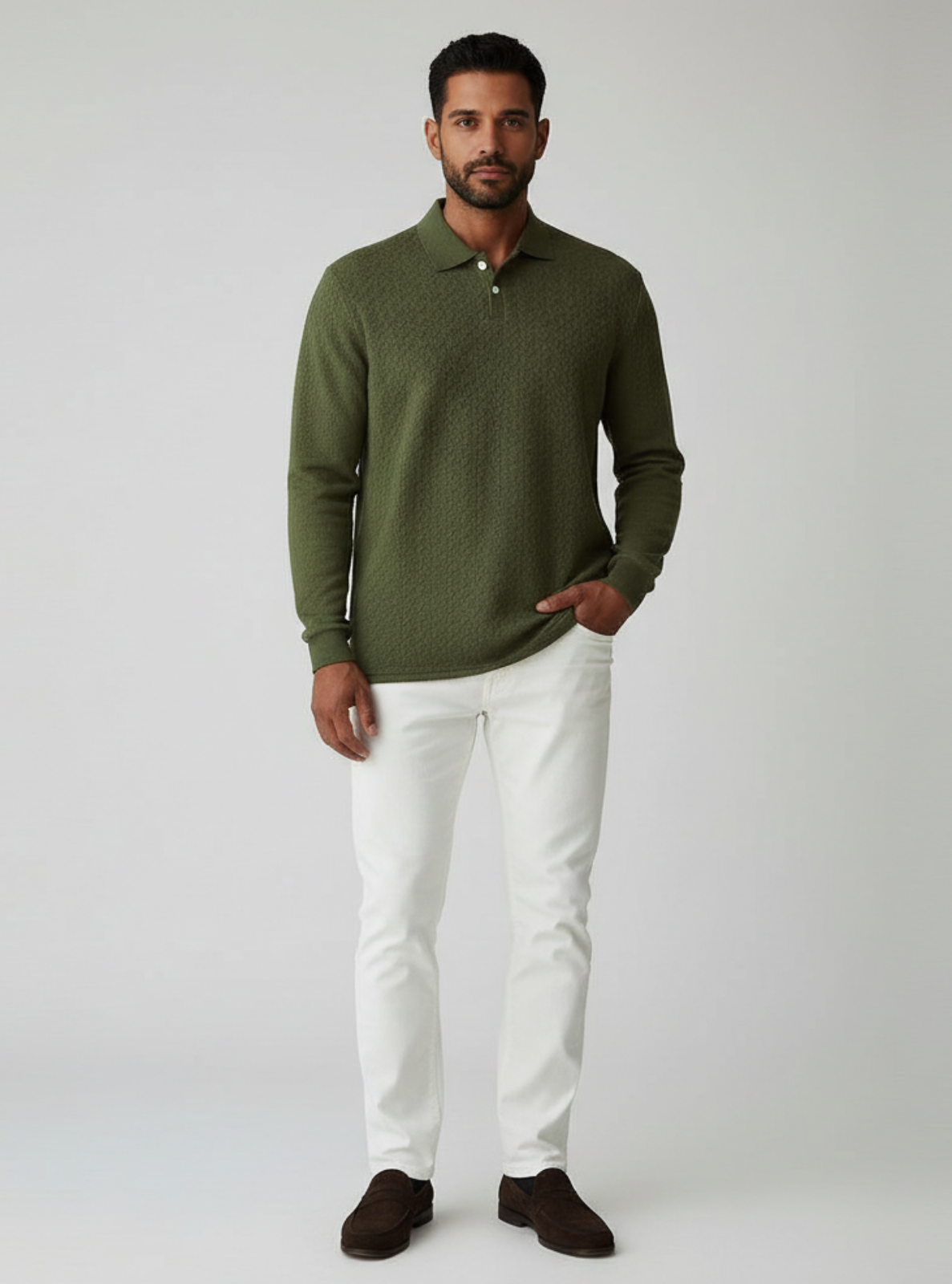 Man wearing a green sweater and white pants on a gray background