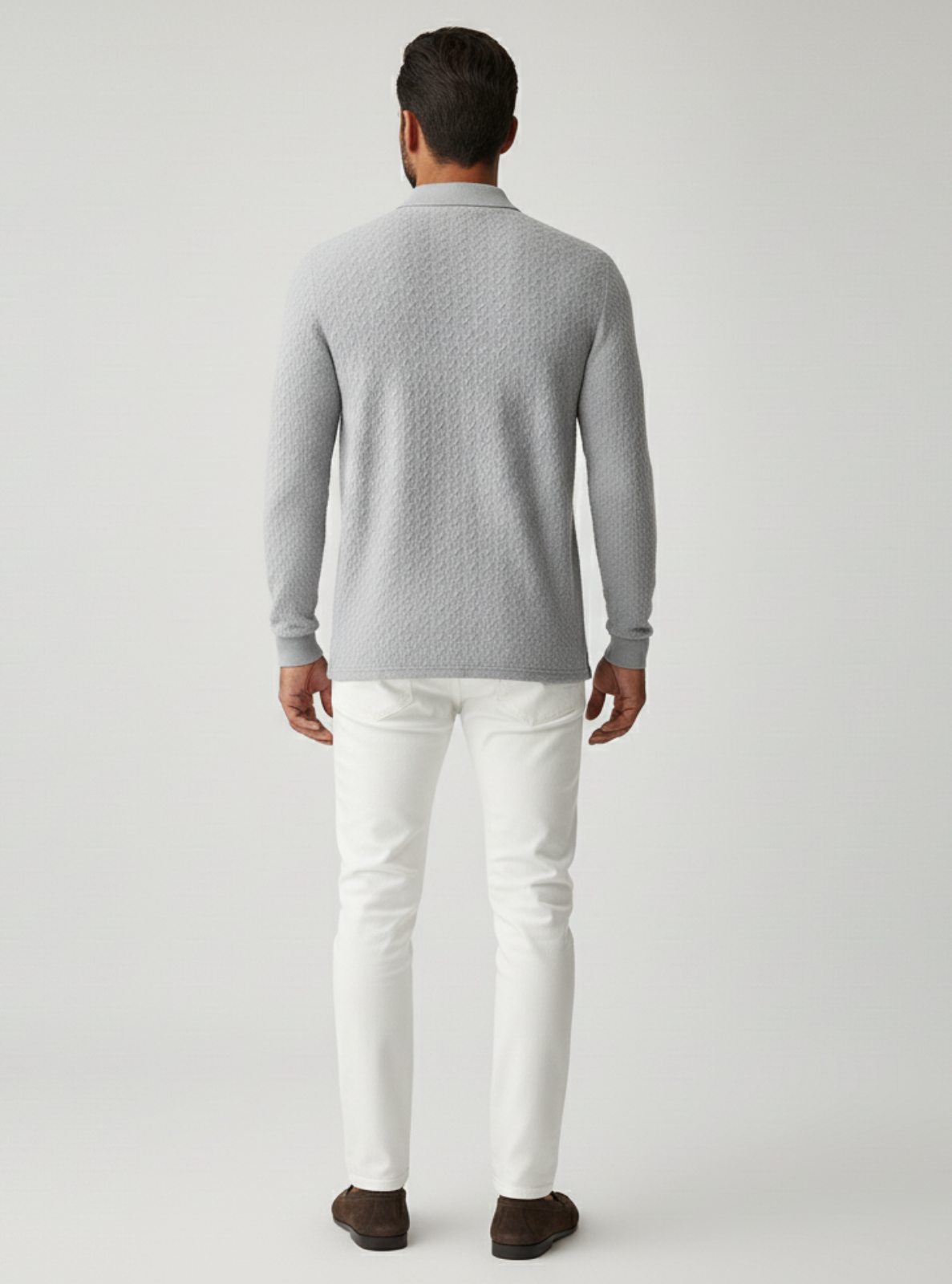 Man wearing a gray sweater and white pants on a light gray background