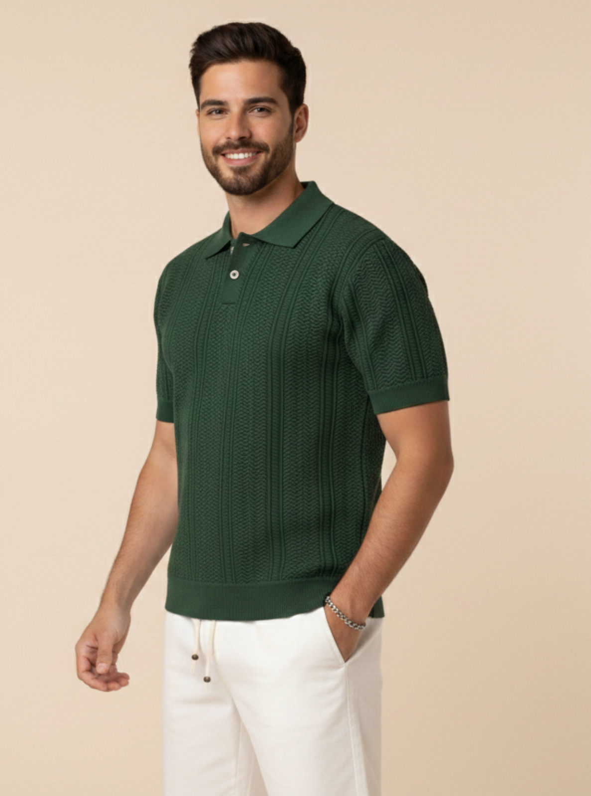 Man wearing a green polo shirt and white pants against a beige background