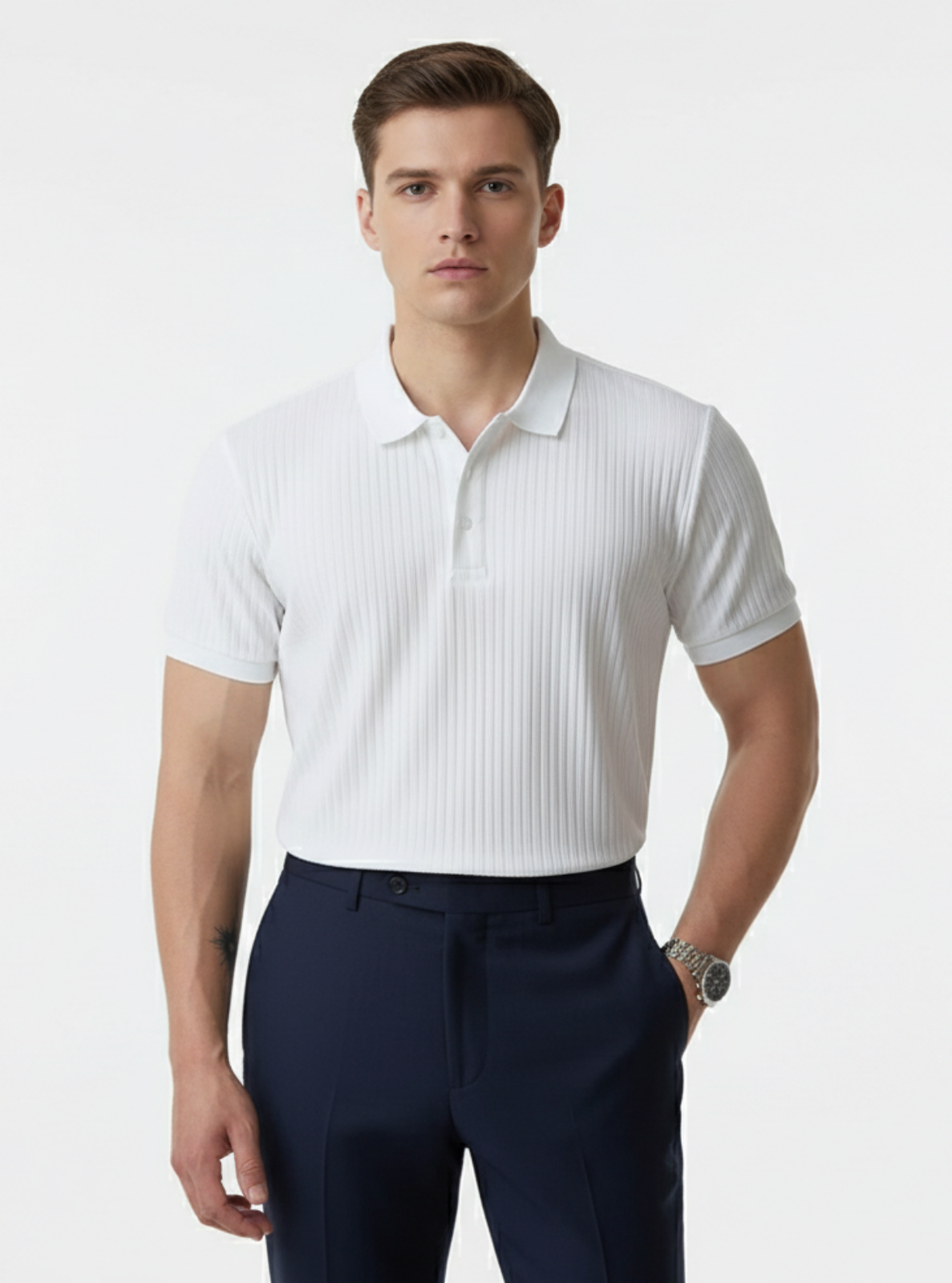 Man wearing a white ribbed polo shirt and navy pants on a light gray background