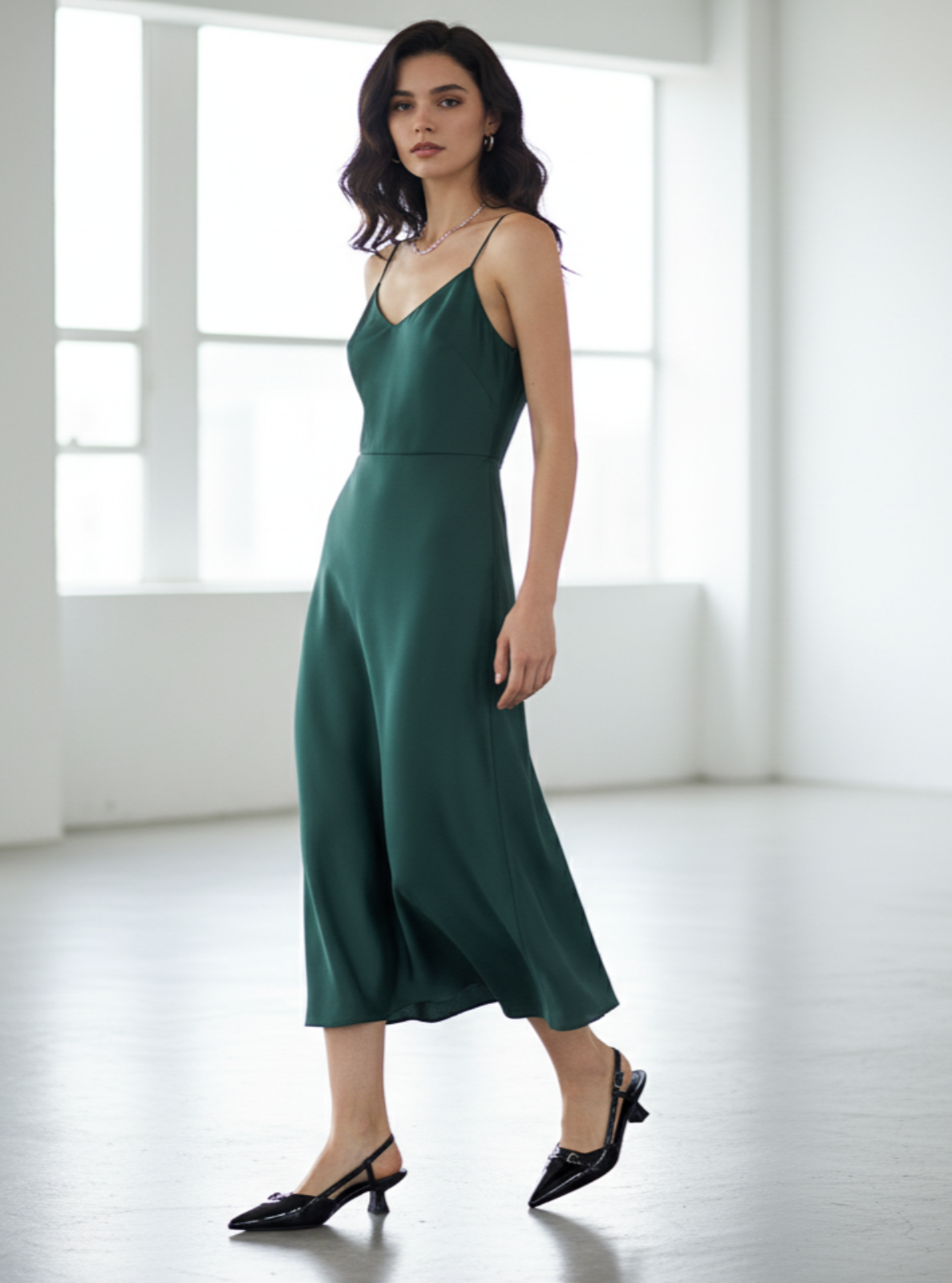Woman wearing a green dress in a minimal white room