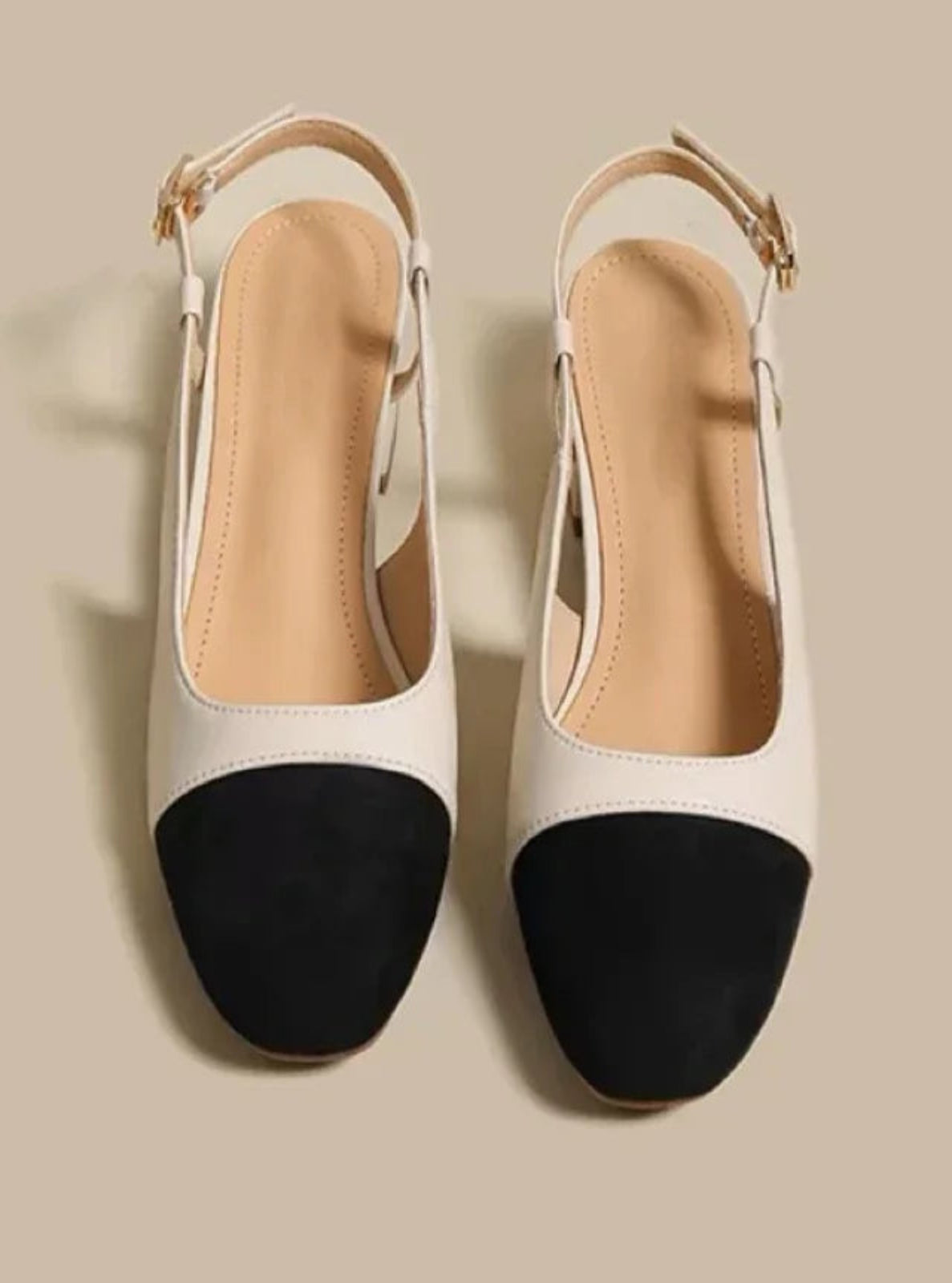 White and black shoes with a beige background