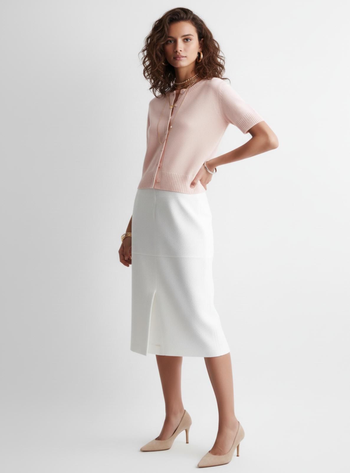 Woman wearing a light pink blouse and white skirt on a white background