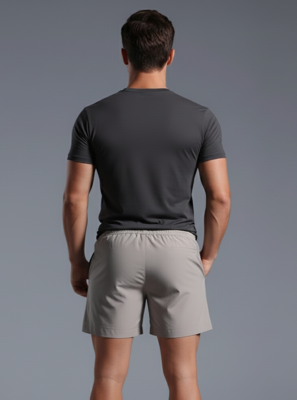 Man wearing a gray t-shirt and shorts on a gray background