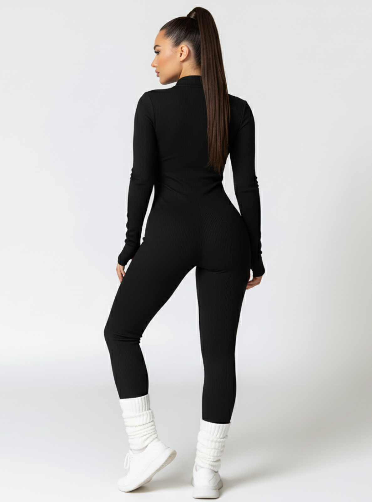 Person wearing a black outfit with white shoes on a white background