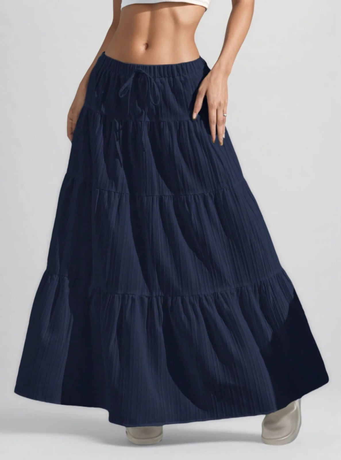 Navy blue tiered skirt worn by a person on a light gray background