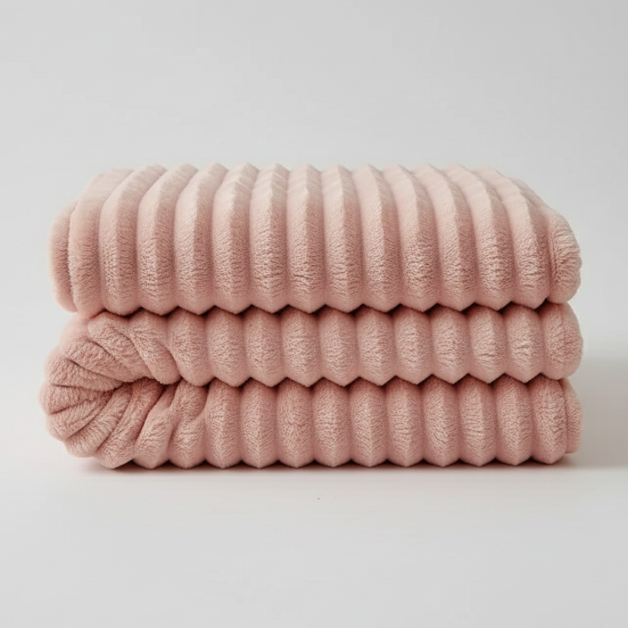 Stack of pink textured blankets on a light gray background