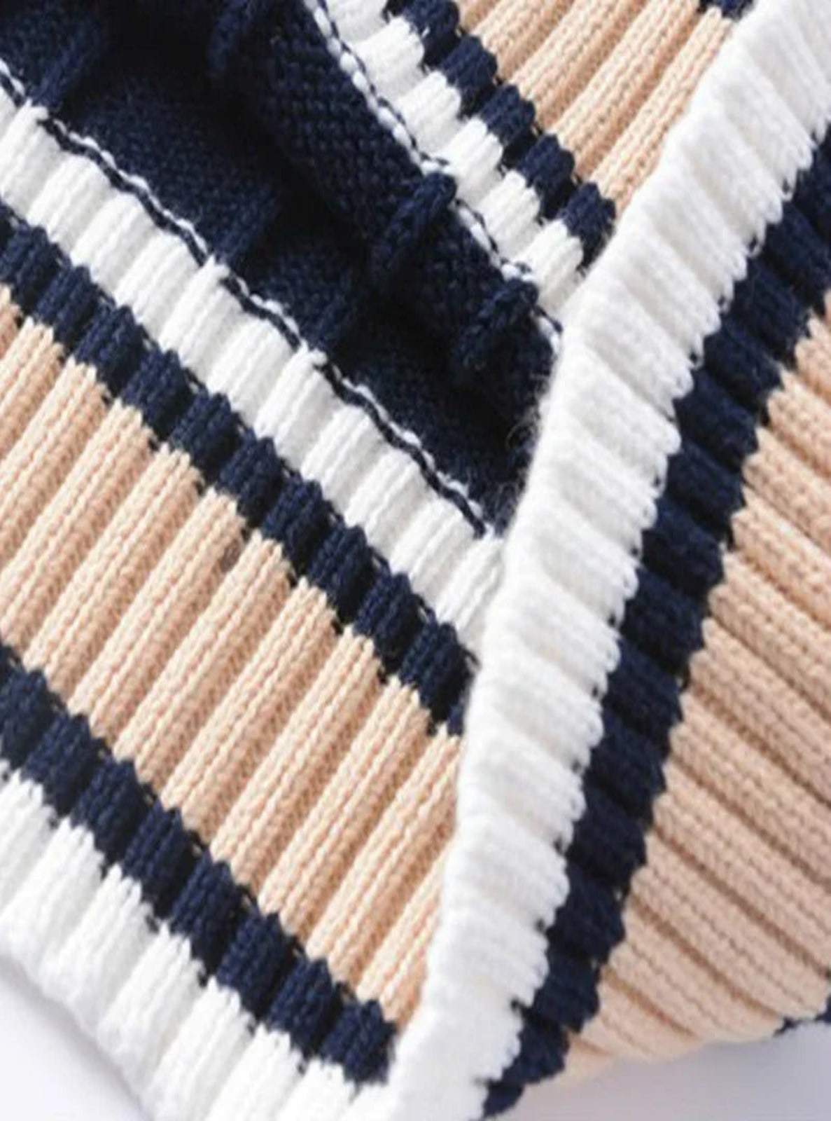 Close-up of a striped fabric with navy, beige, and white colors.