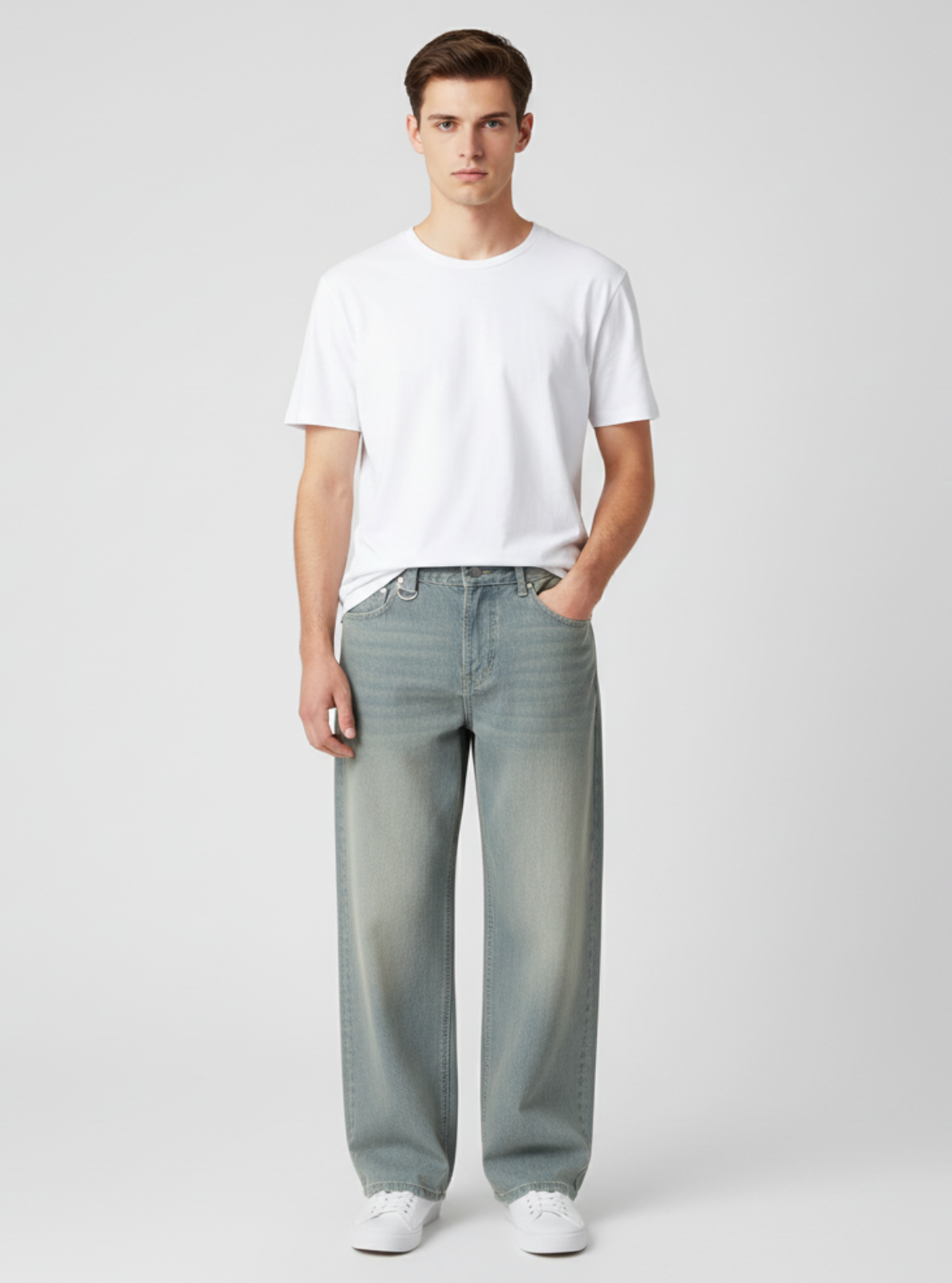 Man wearing a white t-shirt and light gray jeans on a plain background