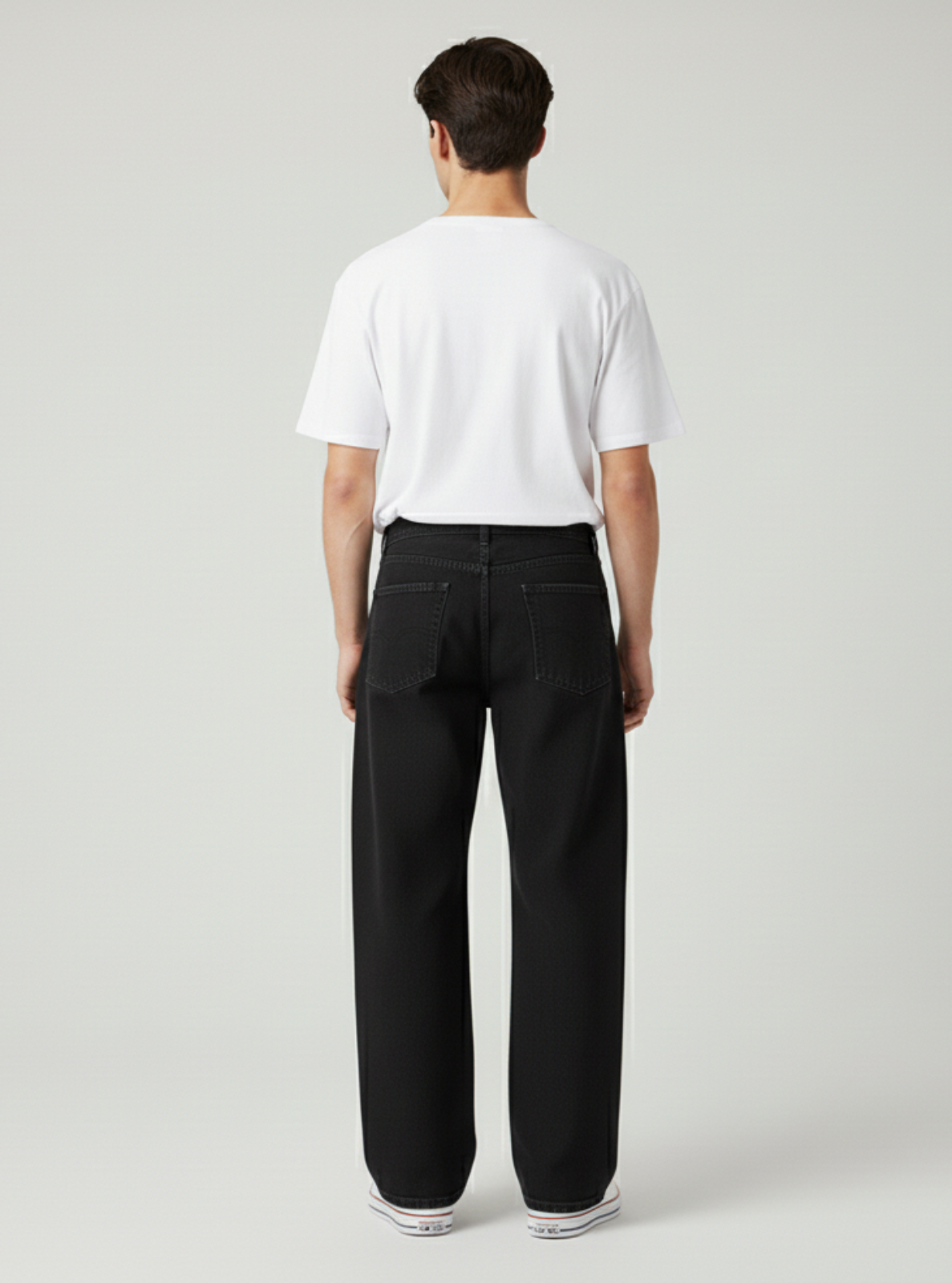 Person wearing a white t-shirt and black pants on a light gray background