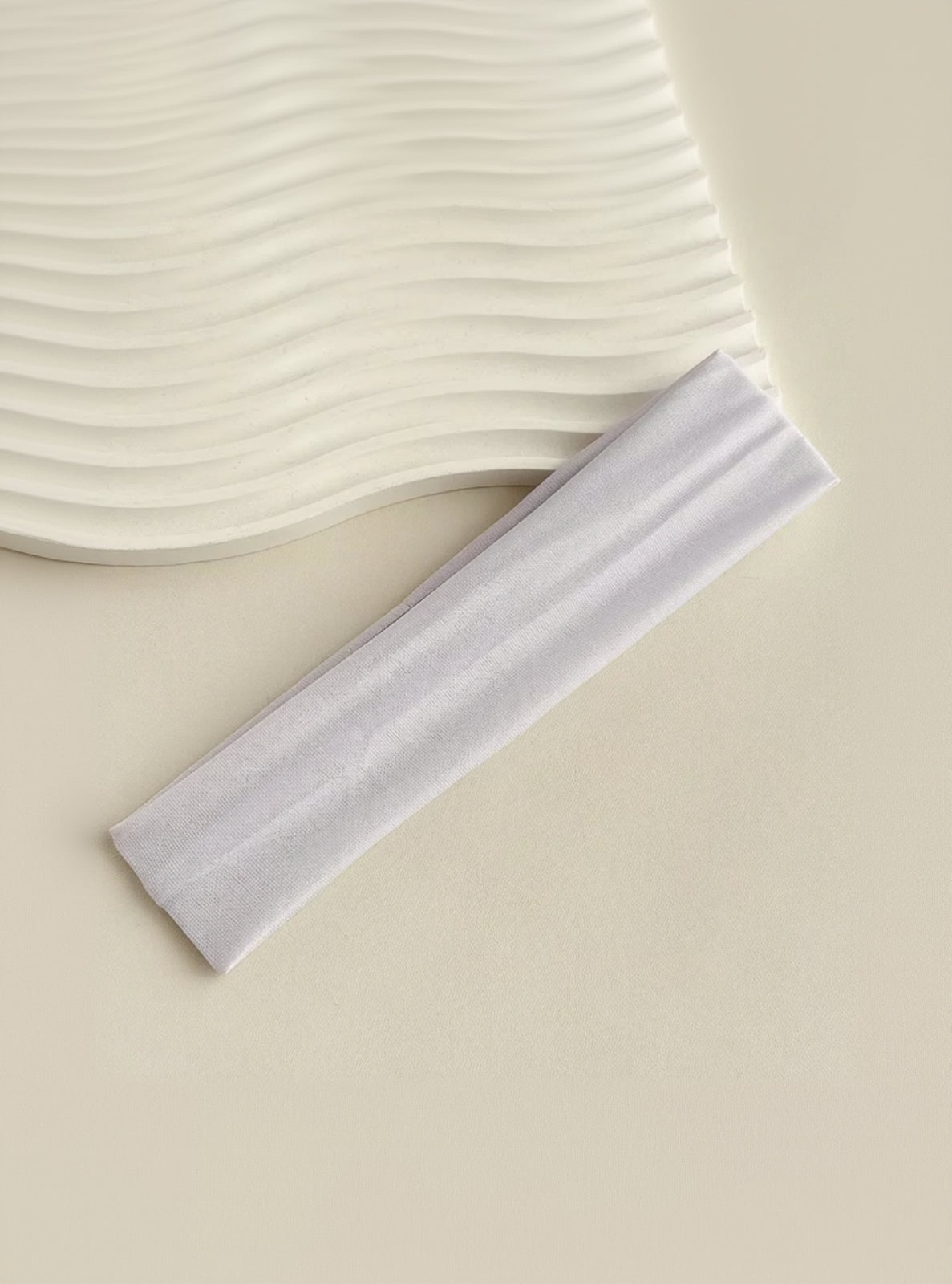 White headband on a beige background