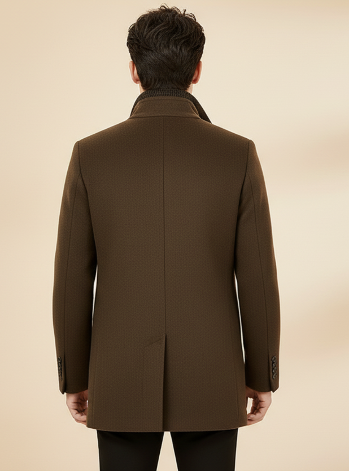 Man wearing a brown coat against a beige background