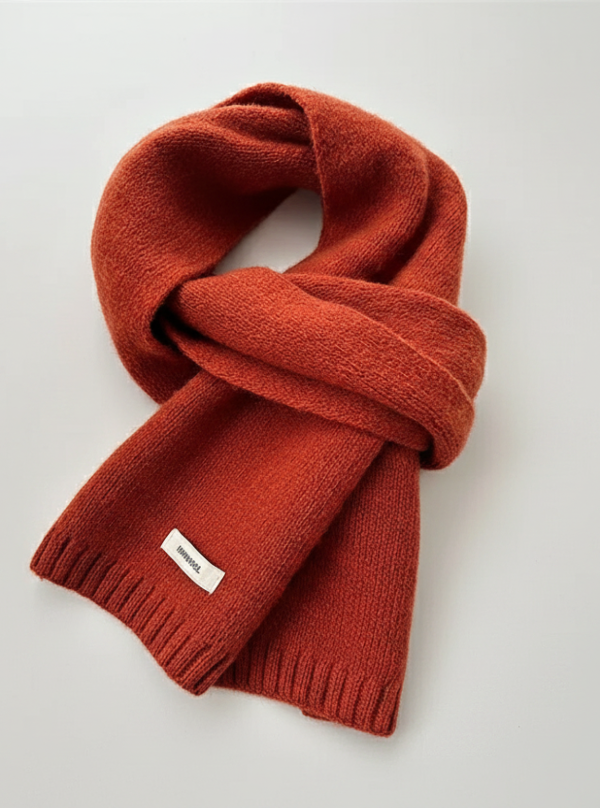 Red scarf with a brand label on a light gray background