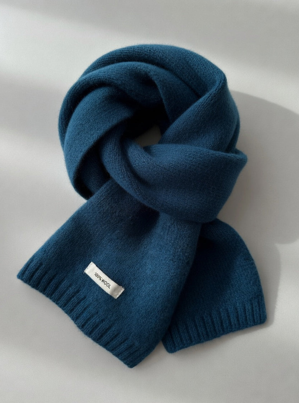 Blue scarf with a brand tag on a light gray background