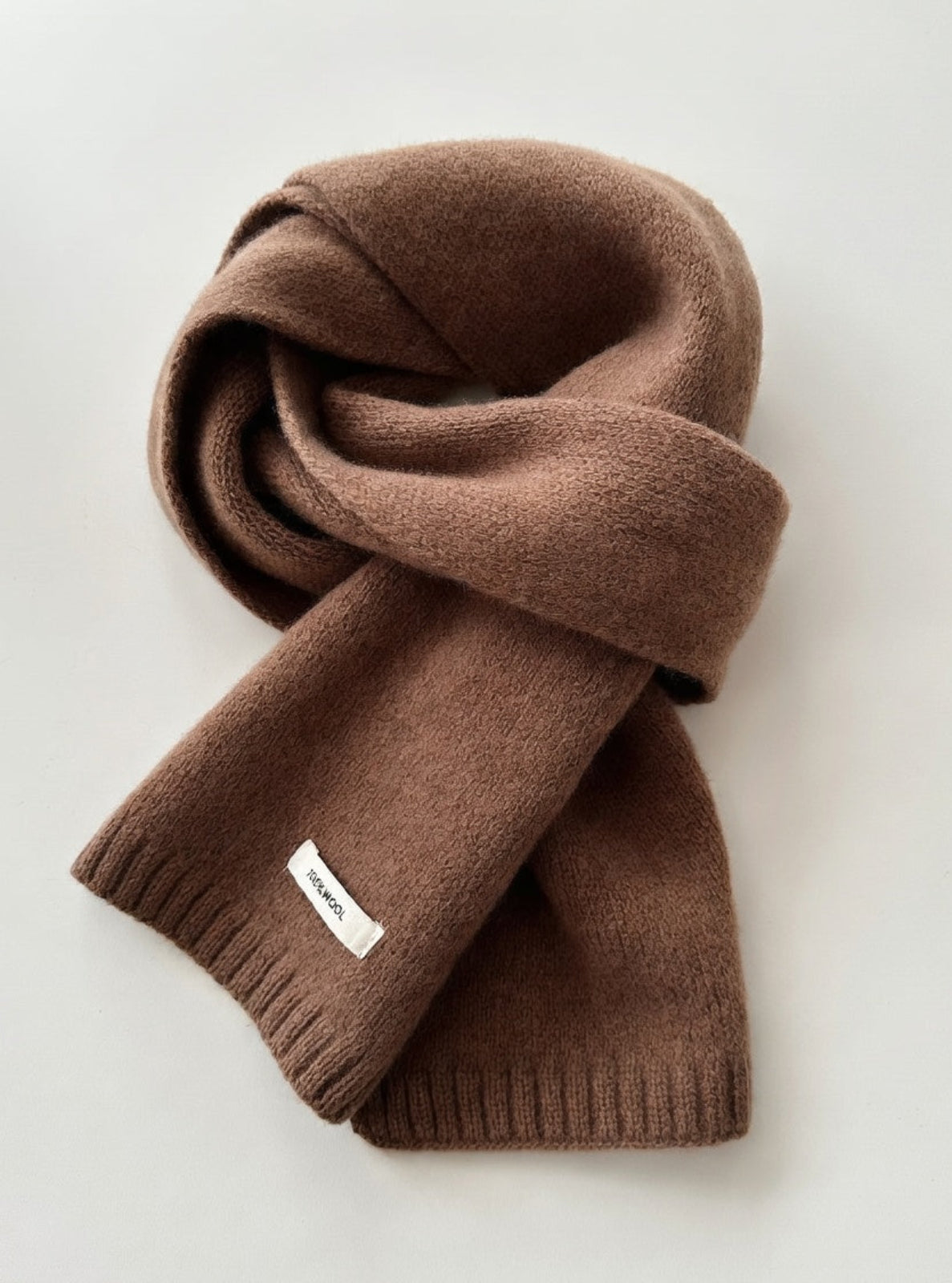 Brown scarf with a brand label on a light gray background