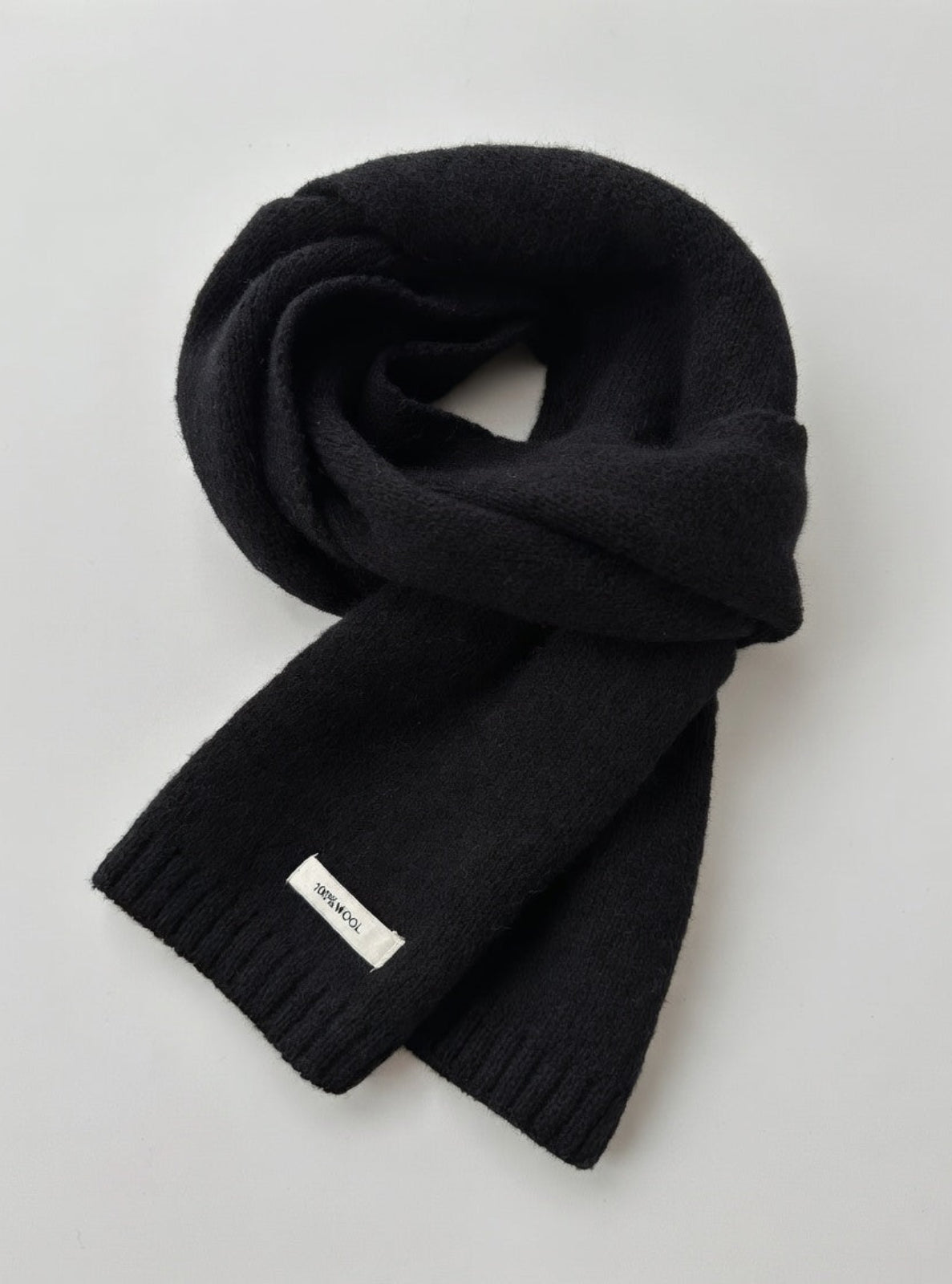Black scarf with a brand label on a light gray background