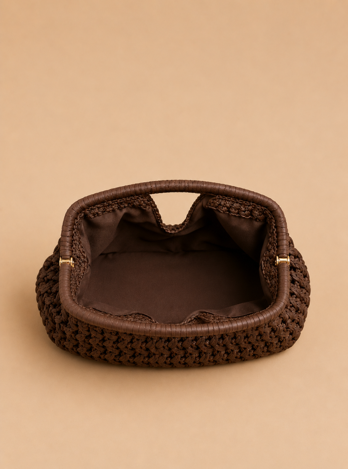 A dark brown woven clutch bag with a matching fabric handle and a dark brown satin-lined interior, set against a solid beige background.